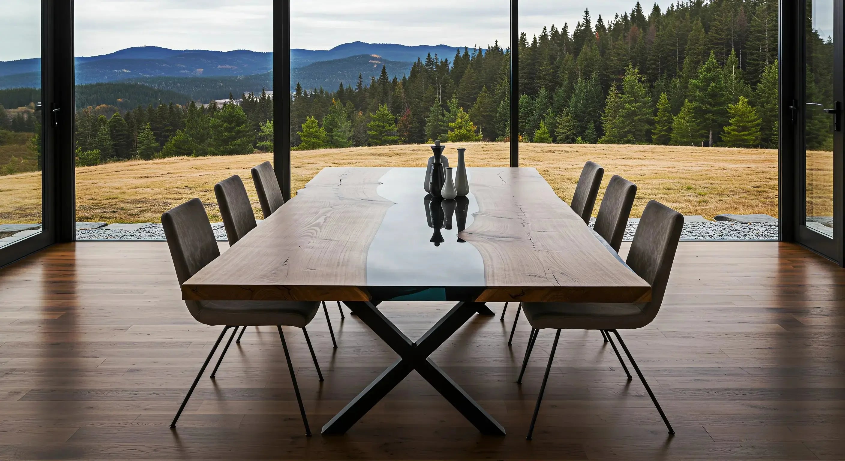 epoxy dining table with black resin and metal x legs surrounded by 6 dining chairs in a luxury cabin dining room with a mountain view