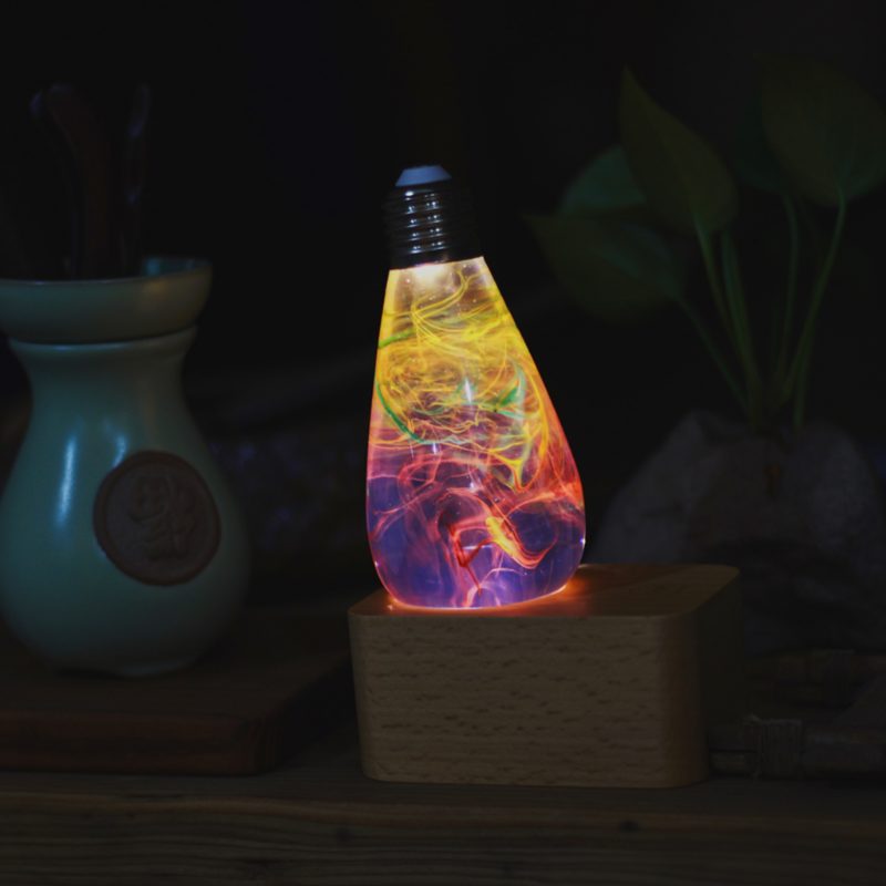 Three handcrafted resin LED light bulbs in a bundle, showing unique color patterns and resin designs