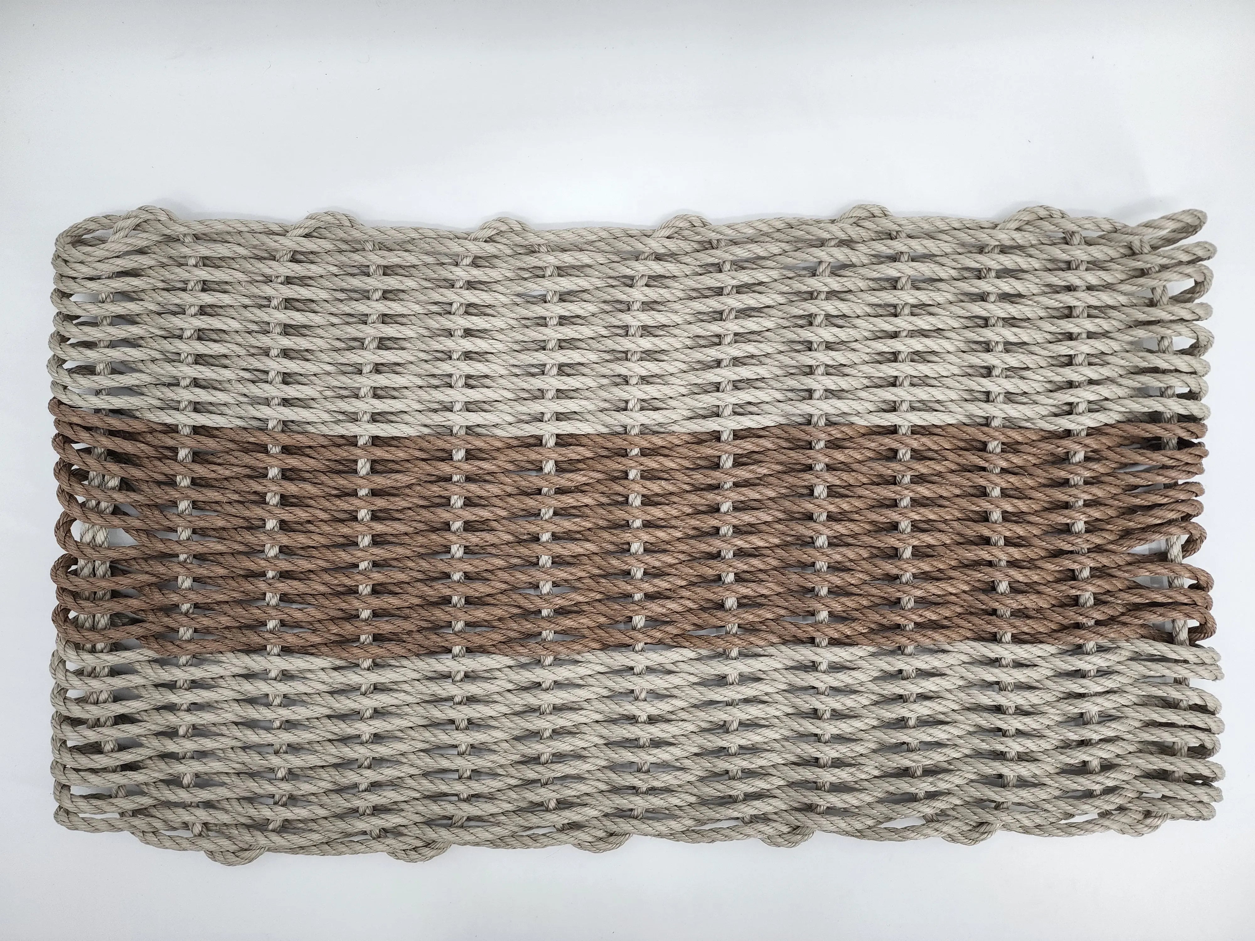 Handmade lobster rope mat in tan and brown colors, displayed on wooden floor