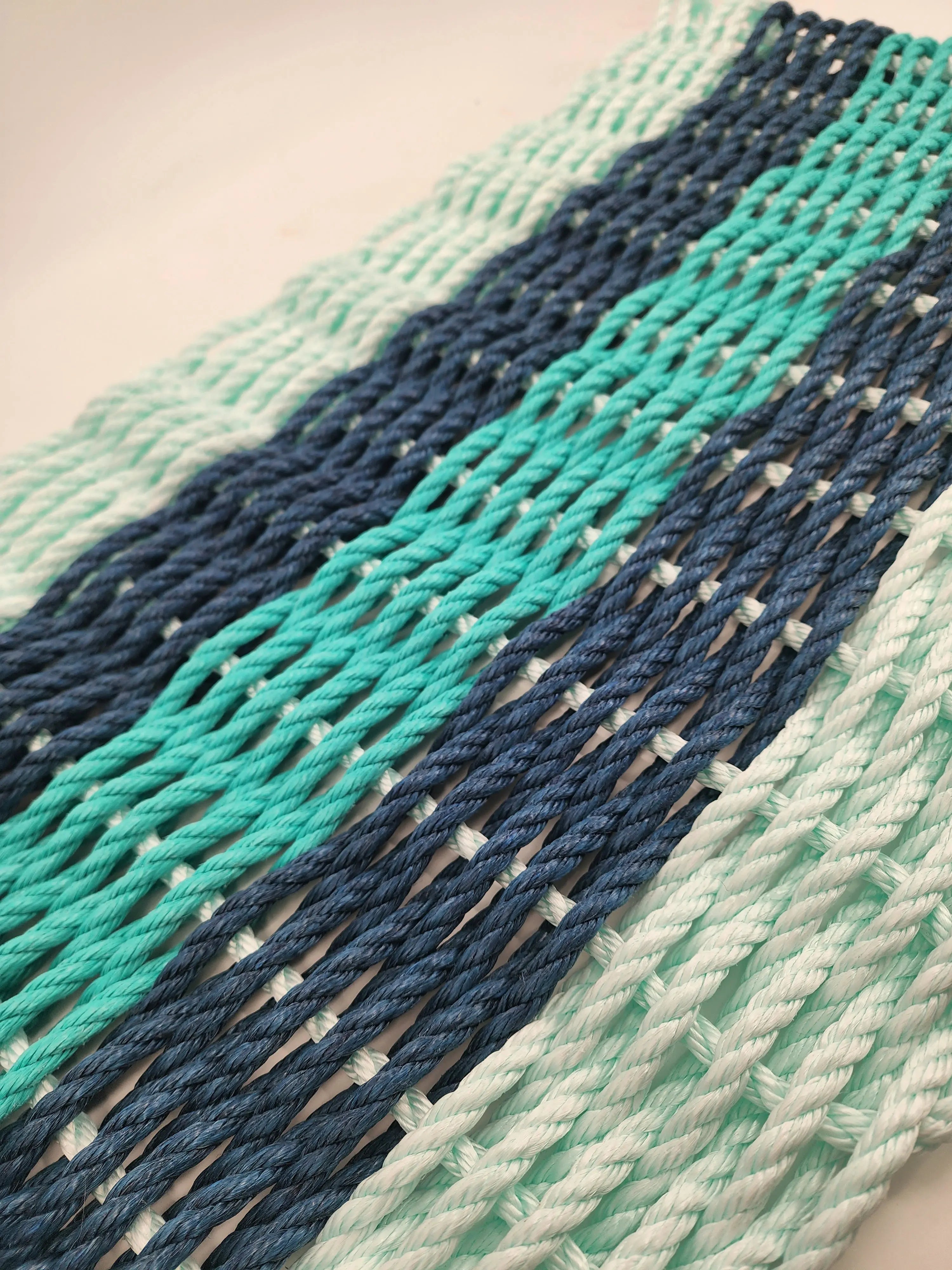Seafoam, navy, and teal striped handmade rope mat made with lobster rope