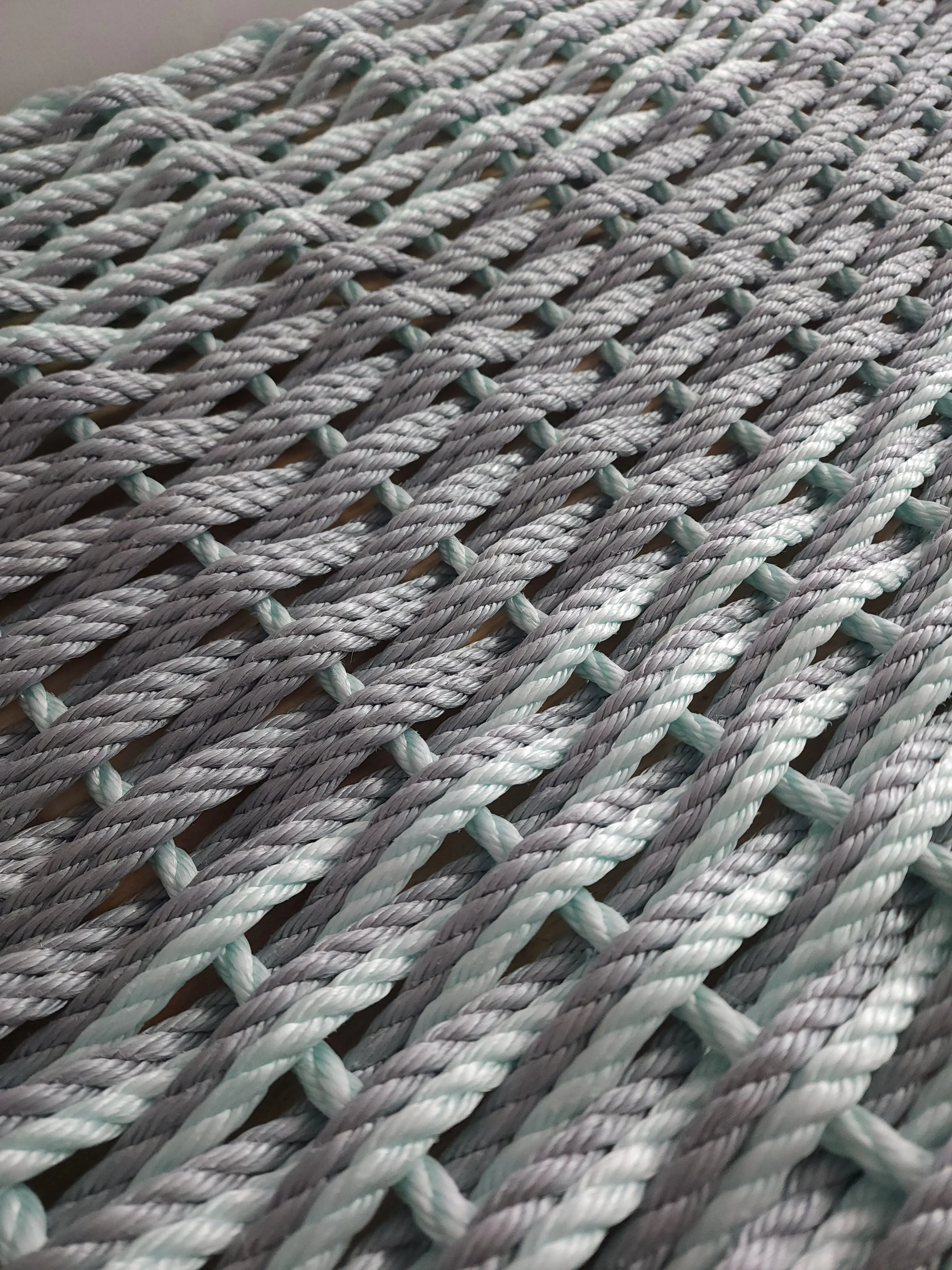 Large double weave lobster rope mat in light gray and seafoam colors