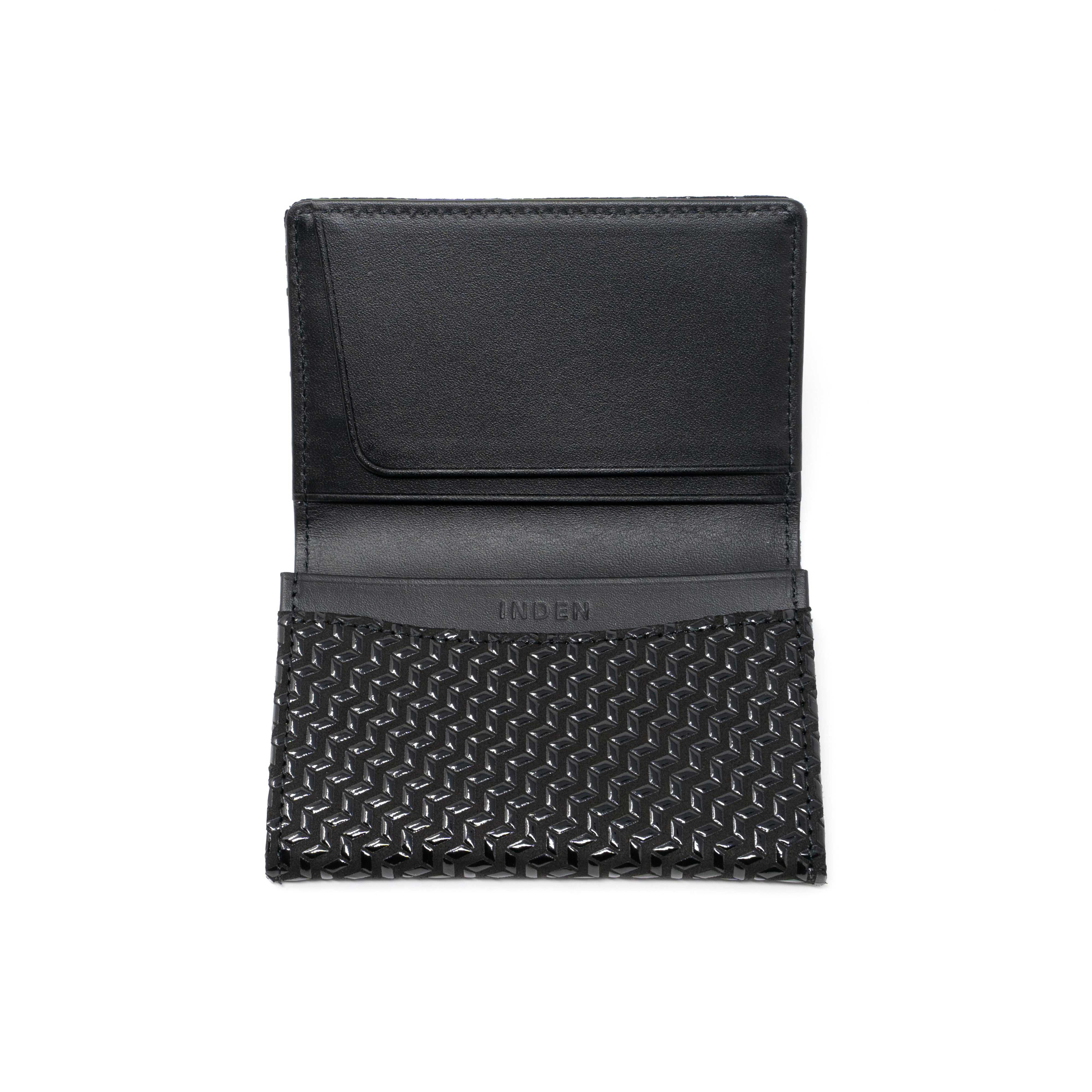Black leather business card case with chevron pattern, open showing card slots