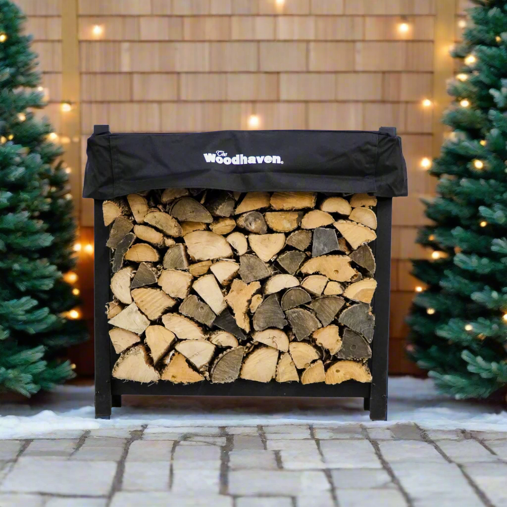 Woodhaven 3 ft Firewood Rack with seasoning cover in black finish holding stacked firewood