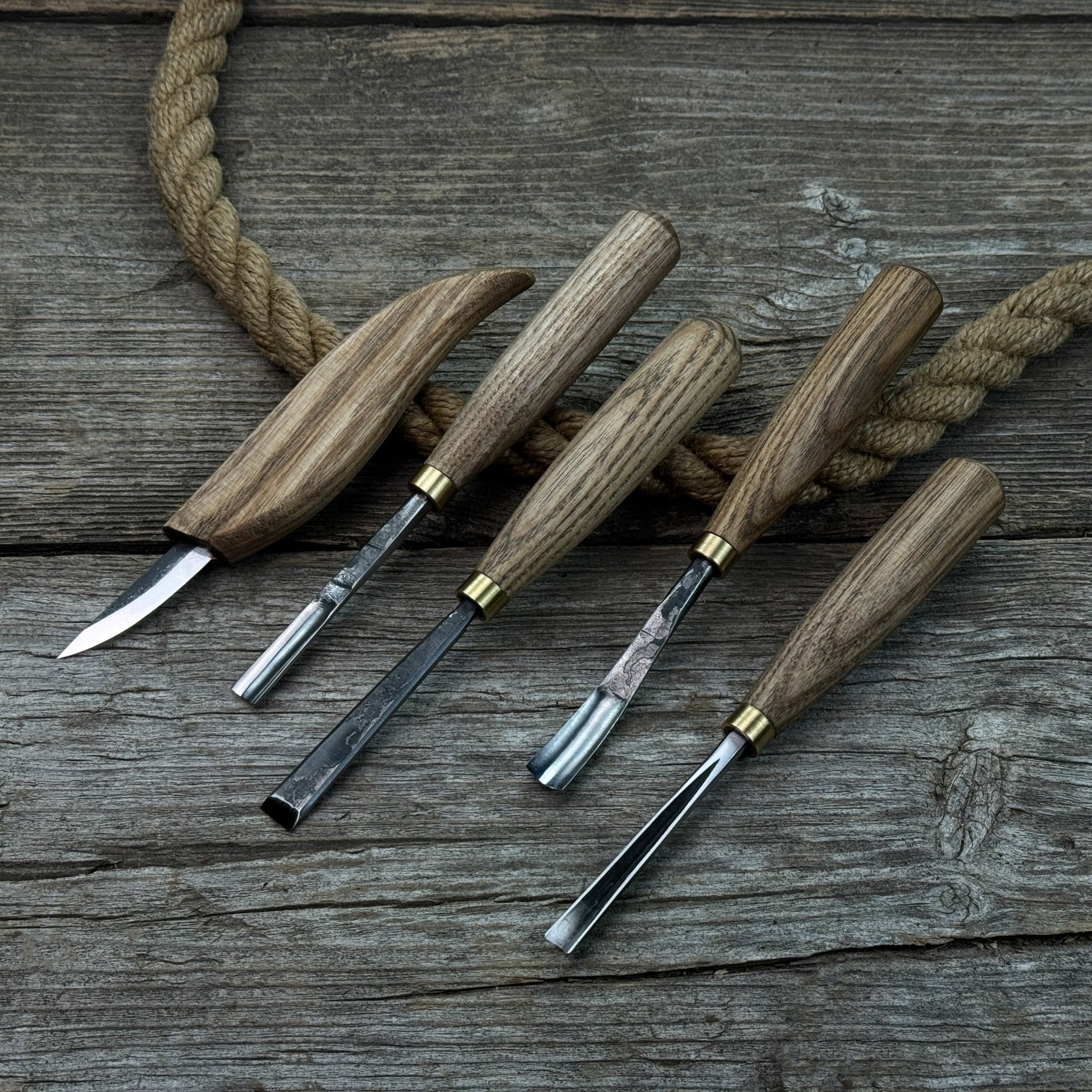 5-piece wood carving tool set with whittling knife and four chisels on wooden surface