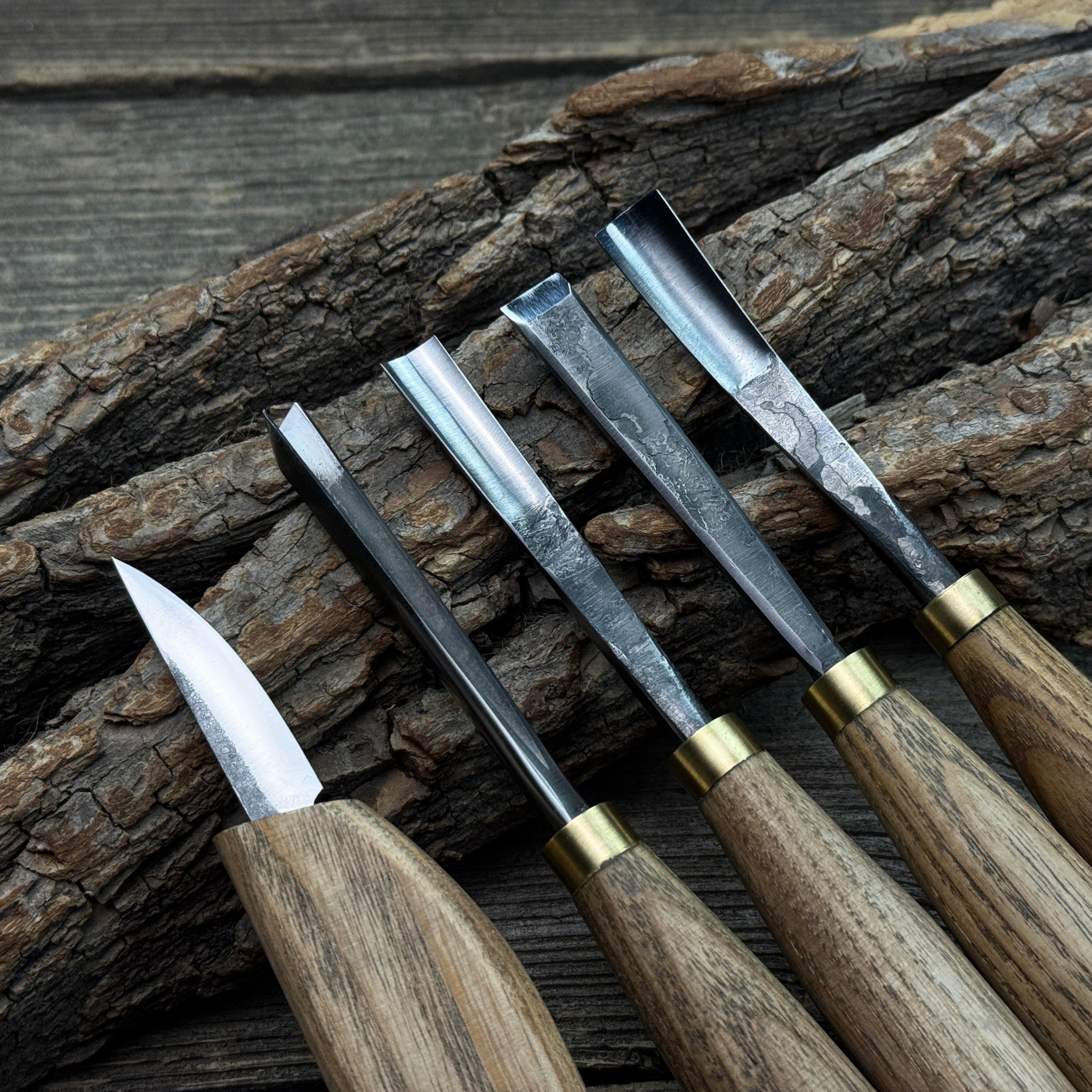 5-piece wood carving tool set with whittling knife and four chisels on wooden surface