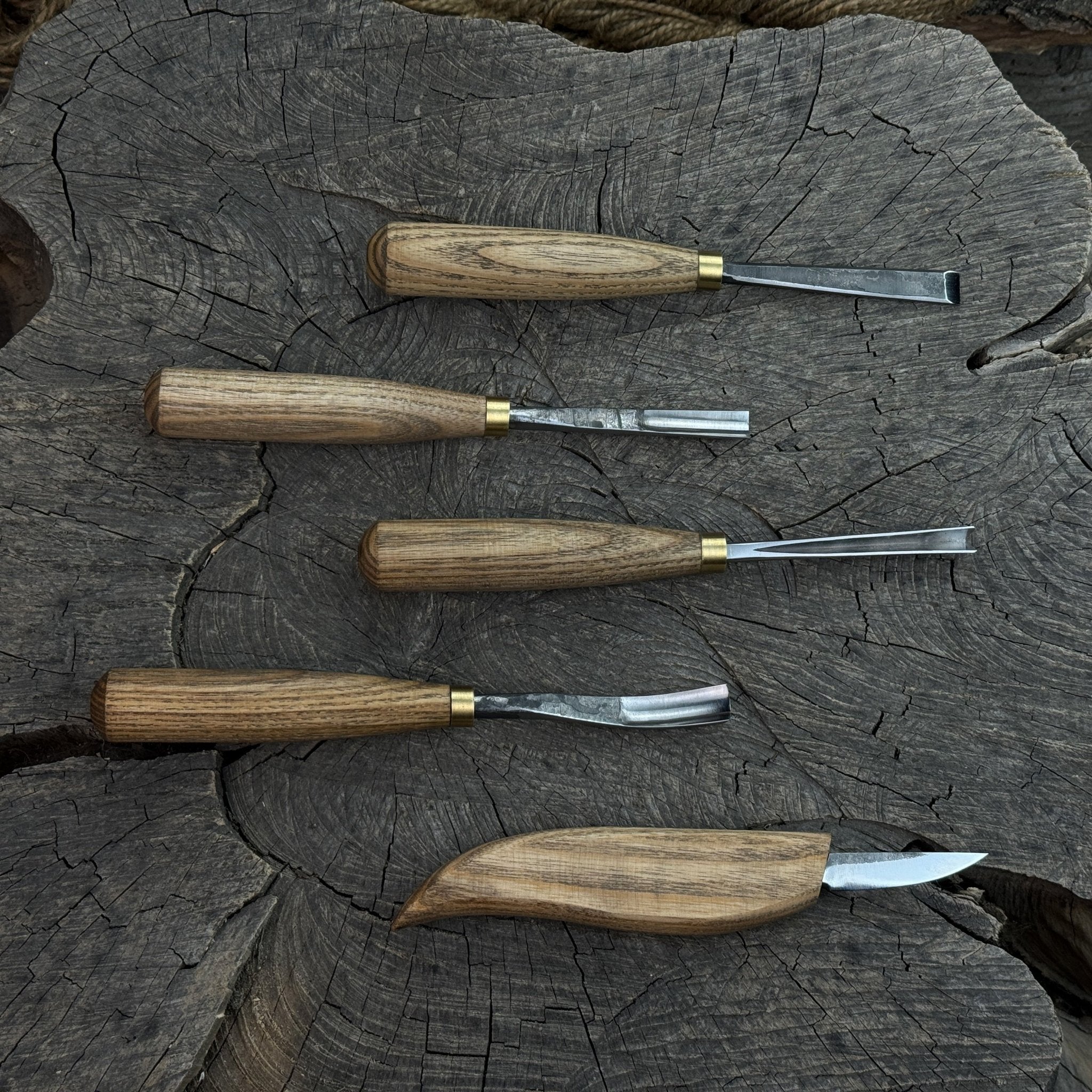 5-piece wood carving tool set with whittling knife and four chisels on wooden surface