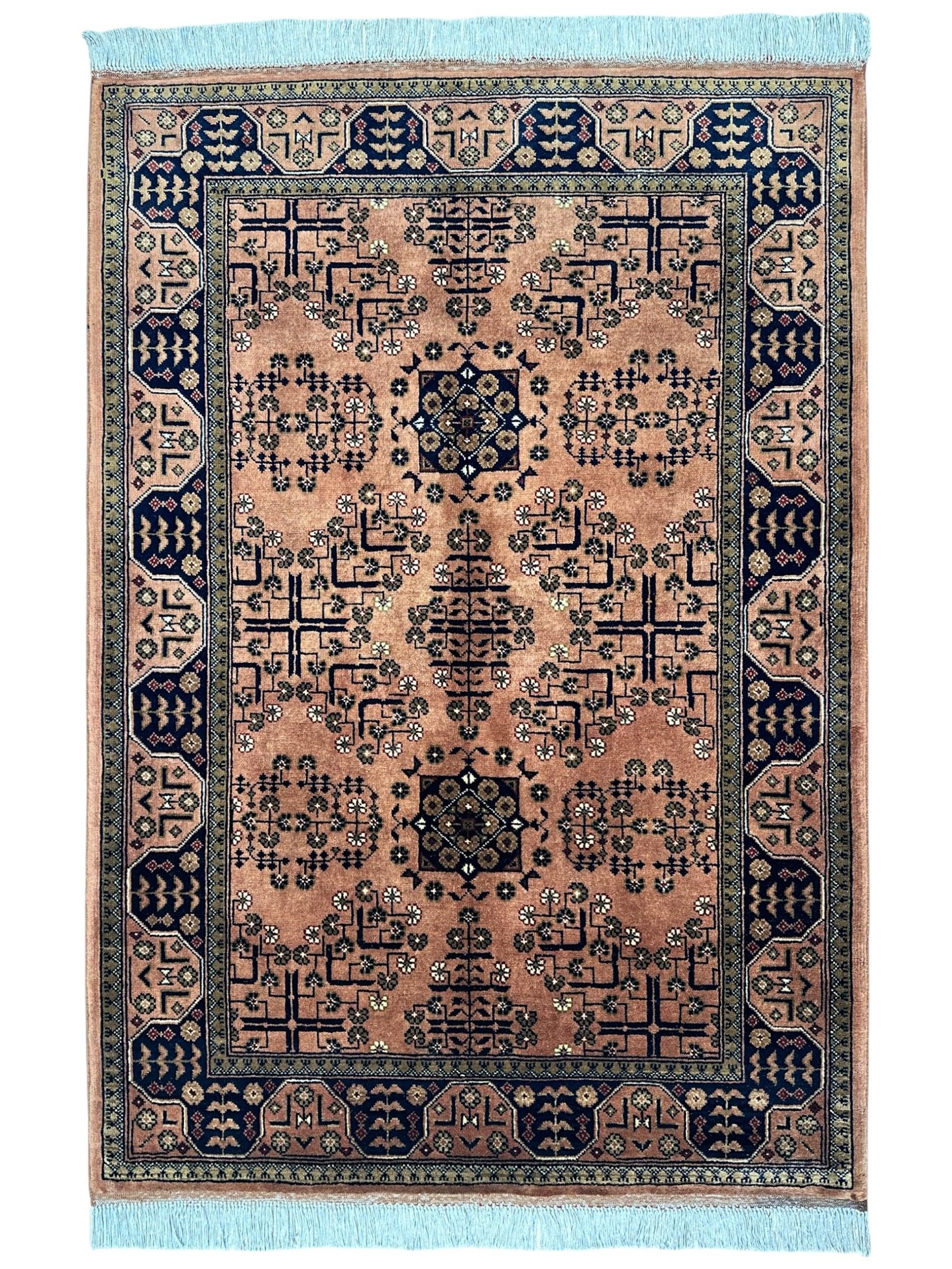 Hand-Knotted Bukharayi Rug in peach, red, ivory, and gold tones with traditional Afghan wool design, displayed on wooden floor