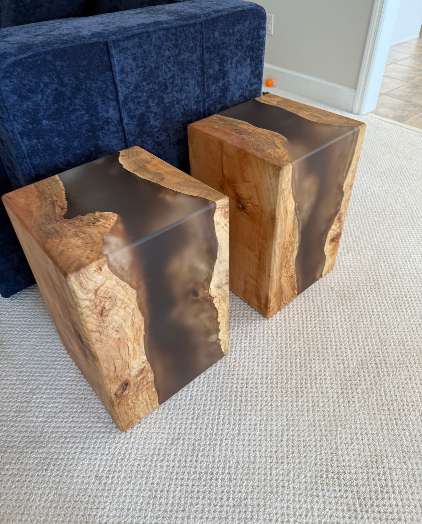 Two wooden side tables with a natural maple finish and epoxy accents on a white background