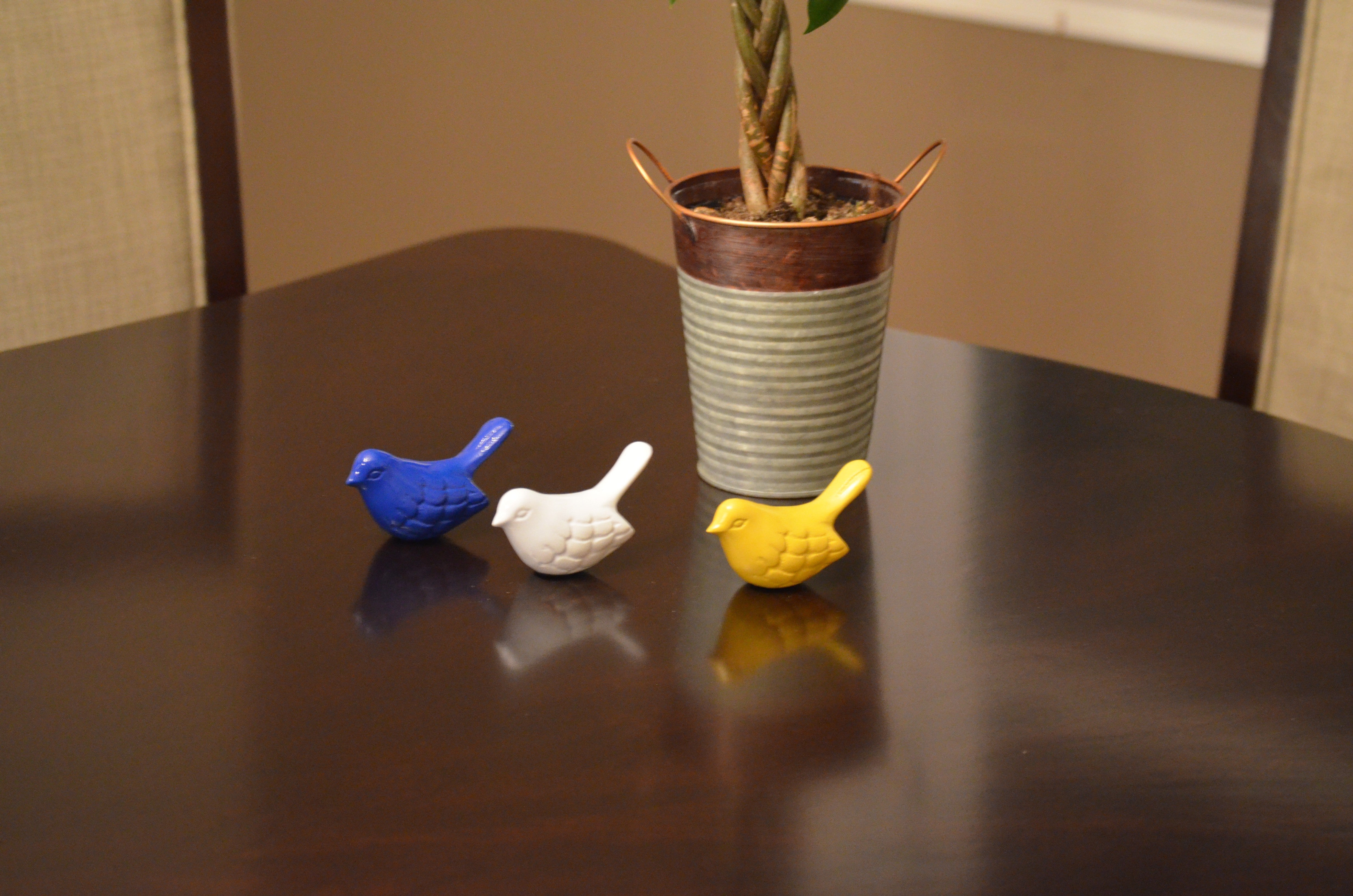 Vibhsa set of three bird figurines in blue, white, and yellow on a tabletop