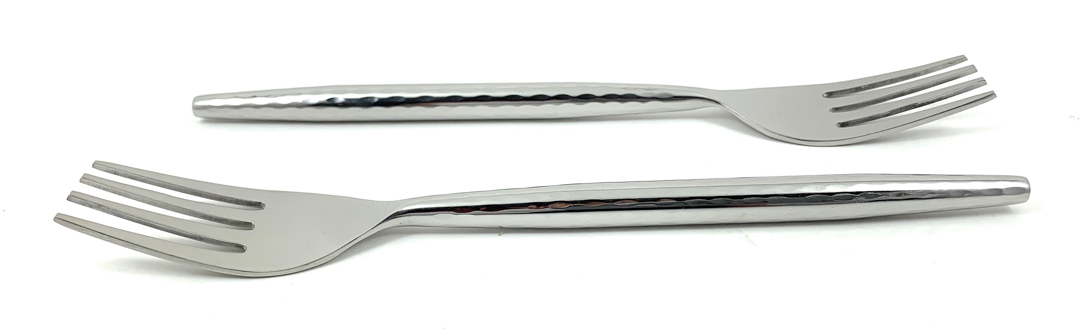 Six Vibhsa salad appetizer forks with hammered textured handles laid out on white cloth