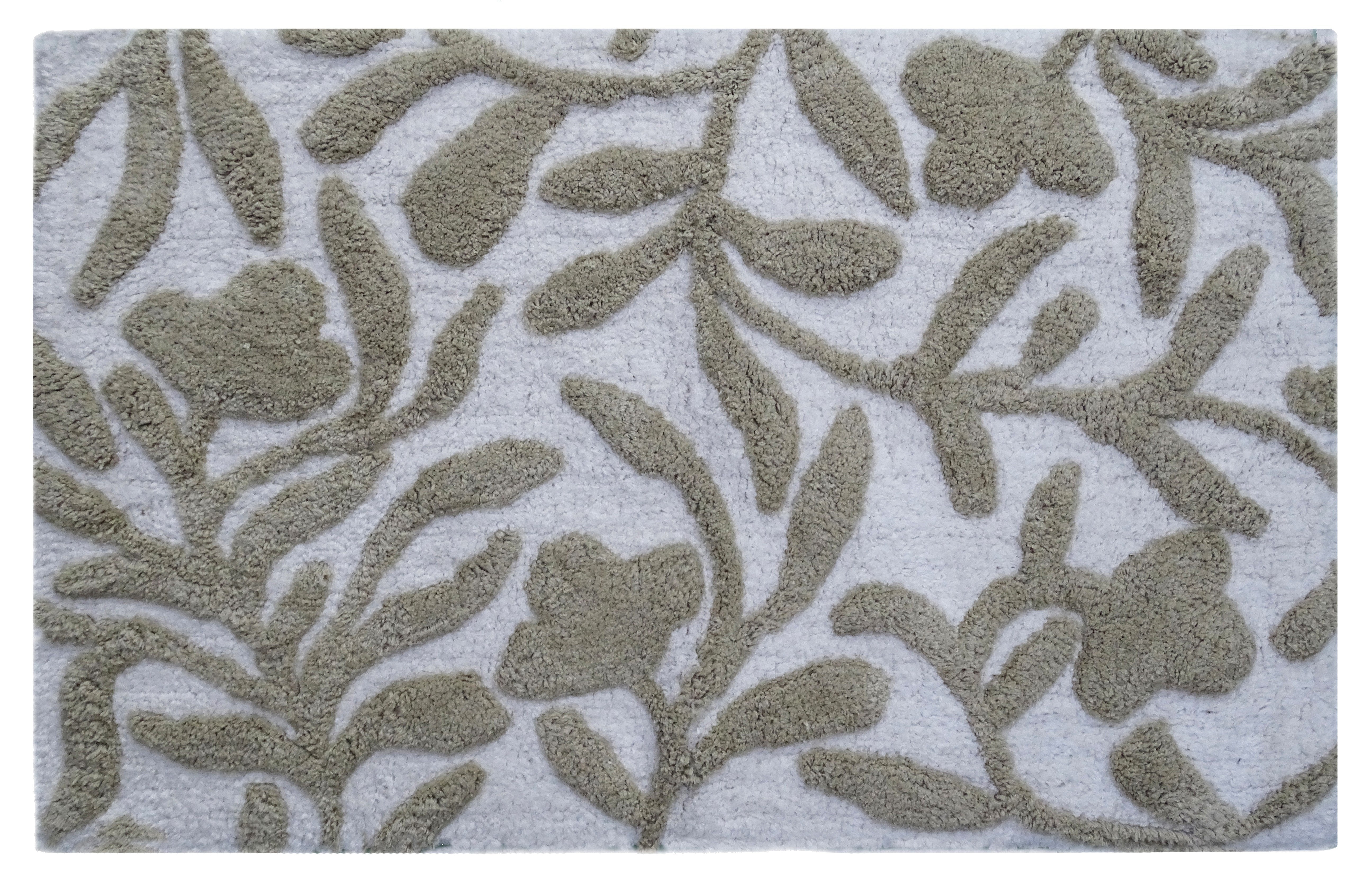 Beige and ivory damask patterned CHICOS HOME bath rug laid on floor