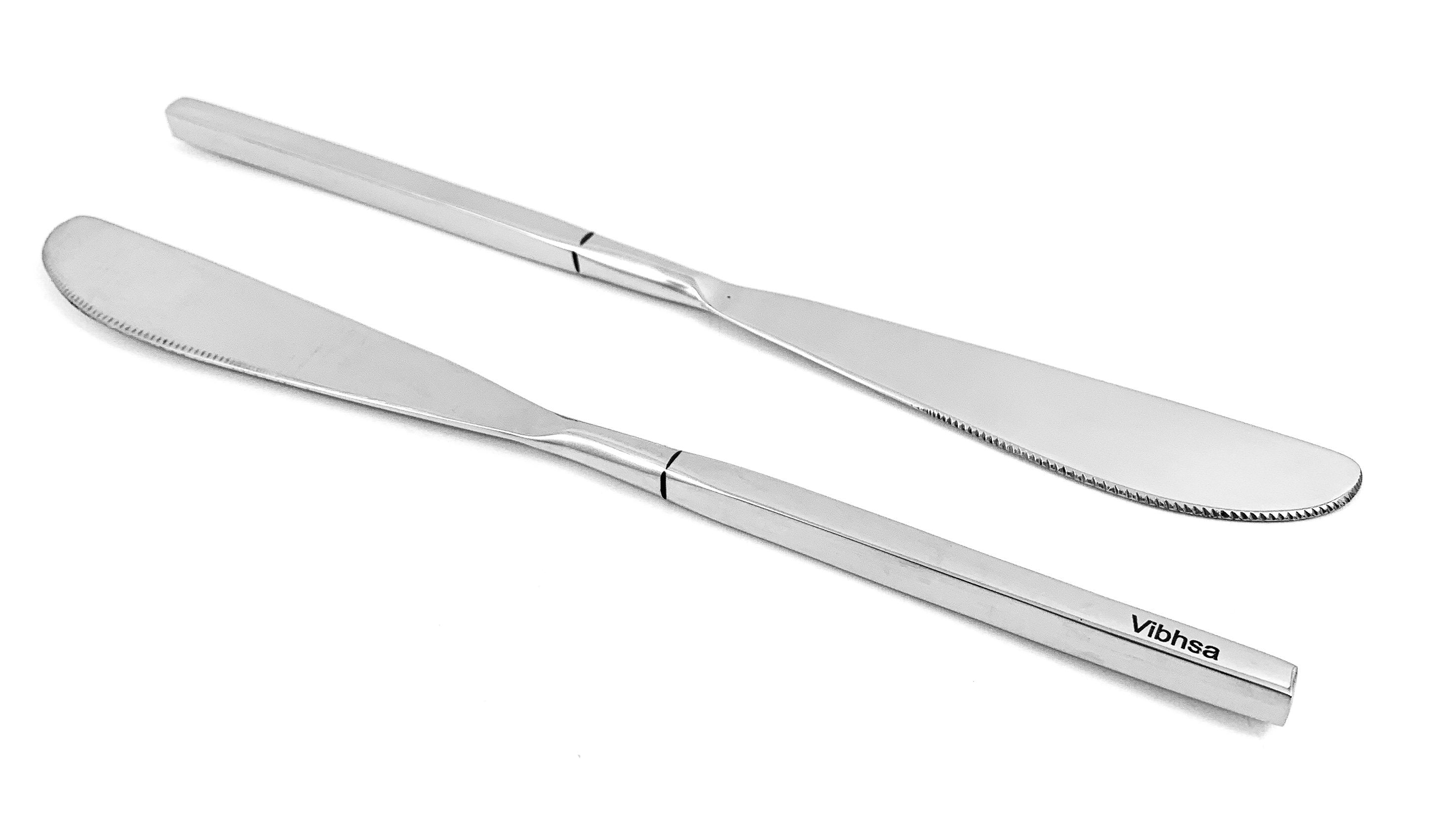 Set of six Vibhsa highly polished stainless steel dinner knives arranged on a wooden surface
