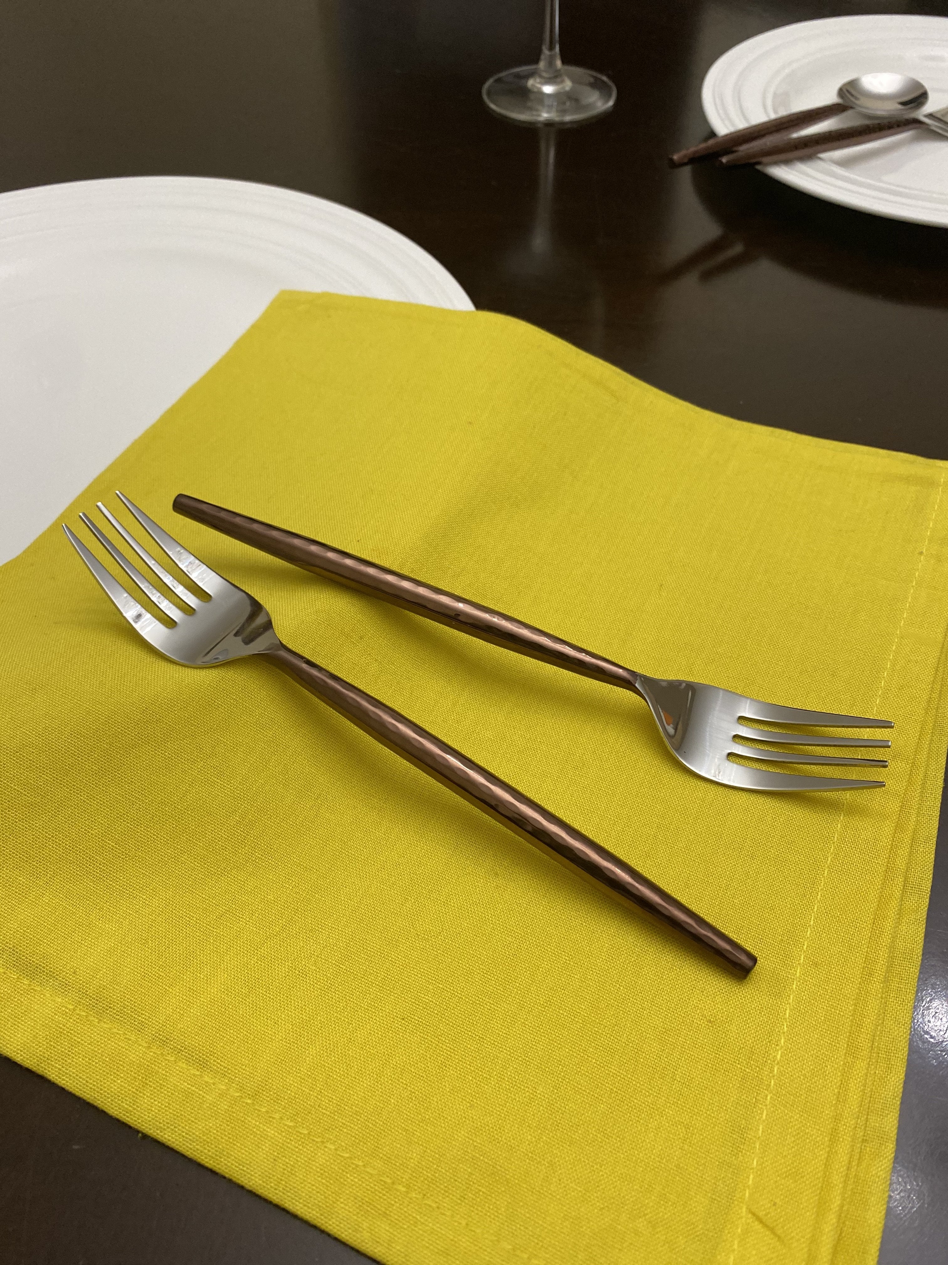 Set of six Vibhsa brown stainless steel dinner forks with hammered handles on a dark surface