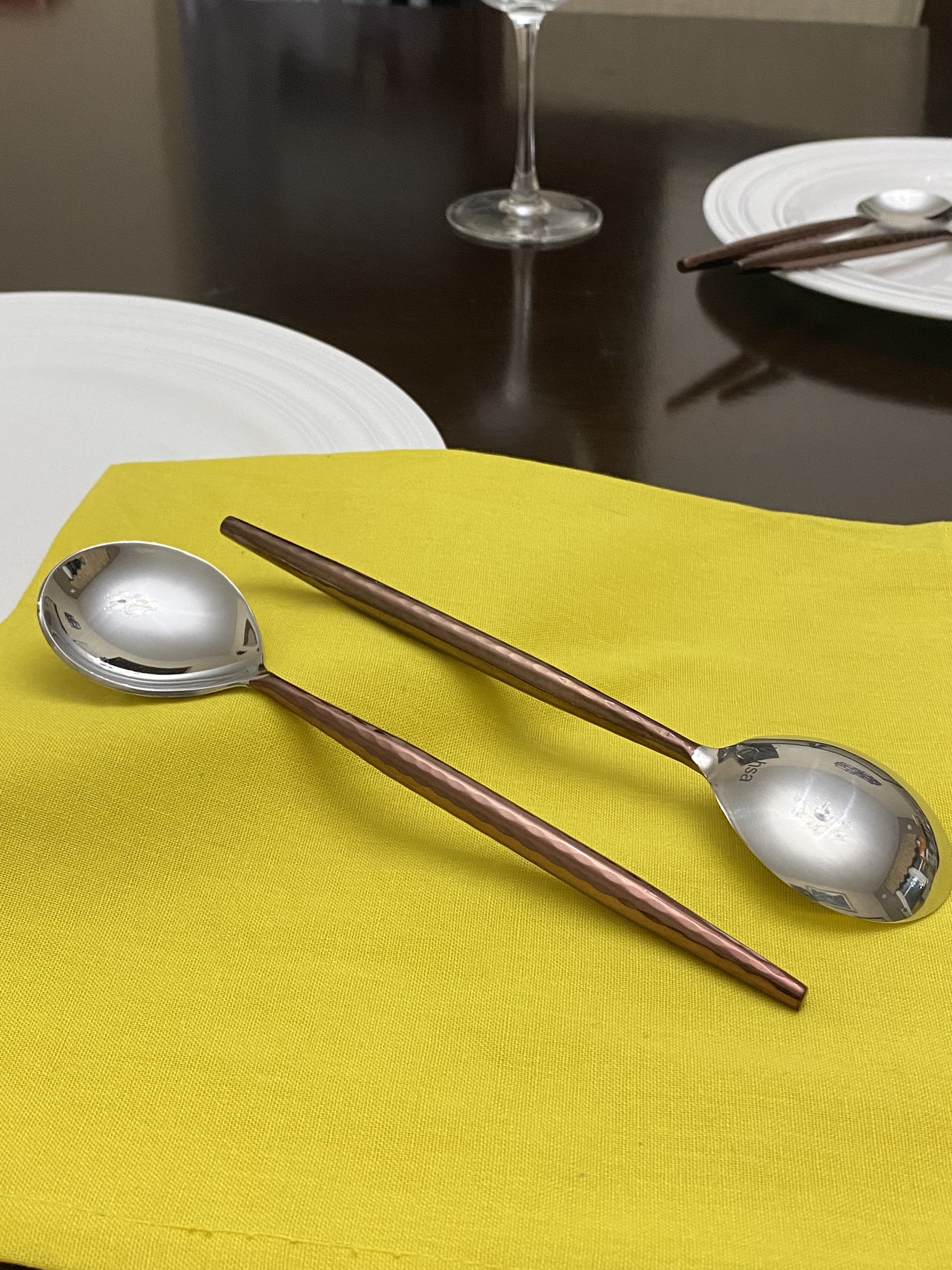 Set of six Vibhsa stainless steel tablespoons with hammered handles and polished brown finish.