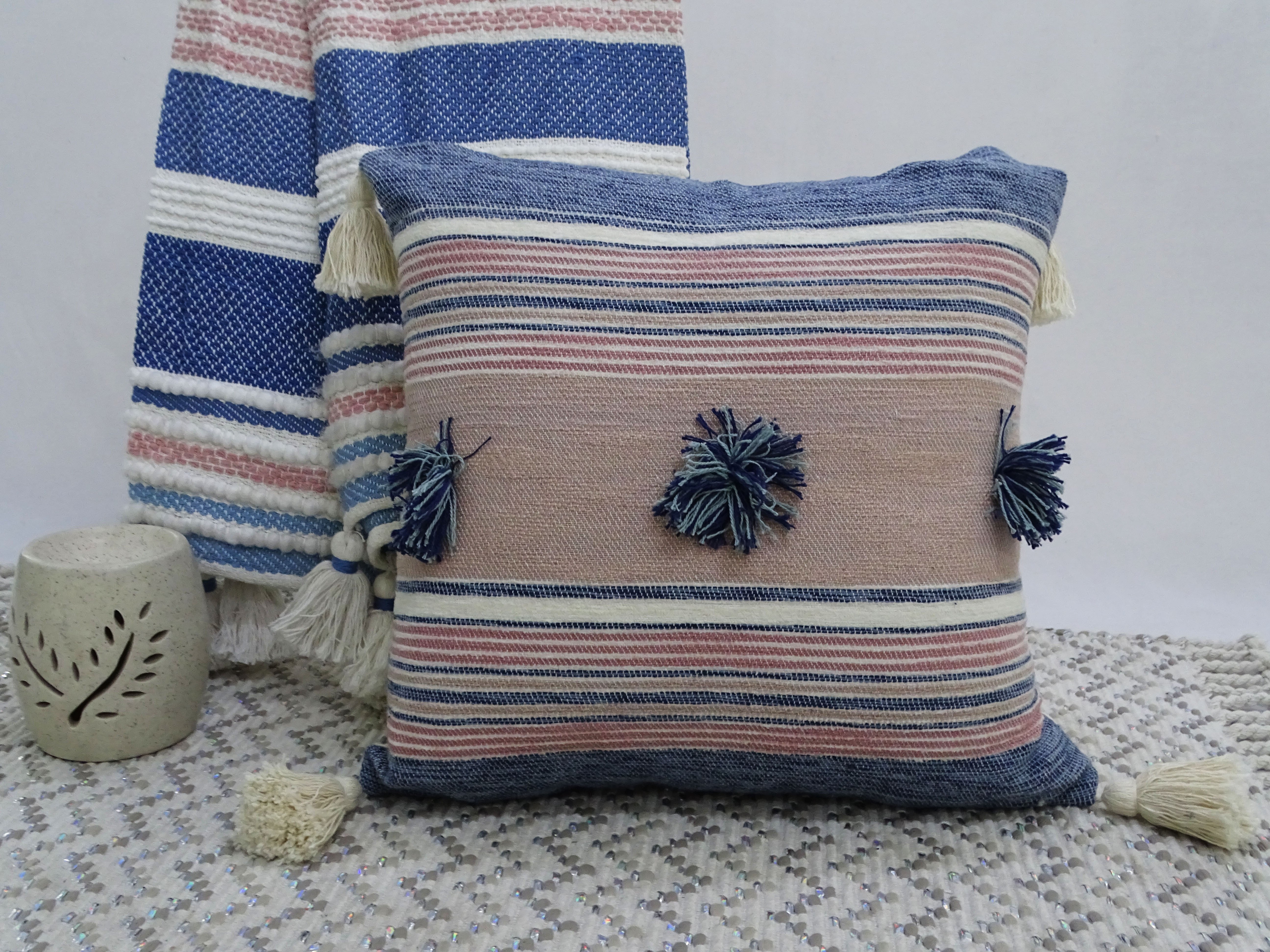 Throw pillow with colorful pom-poms and tassels on couch