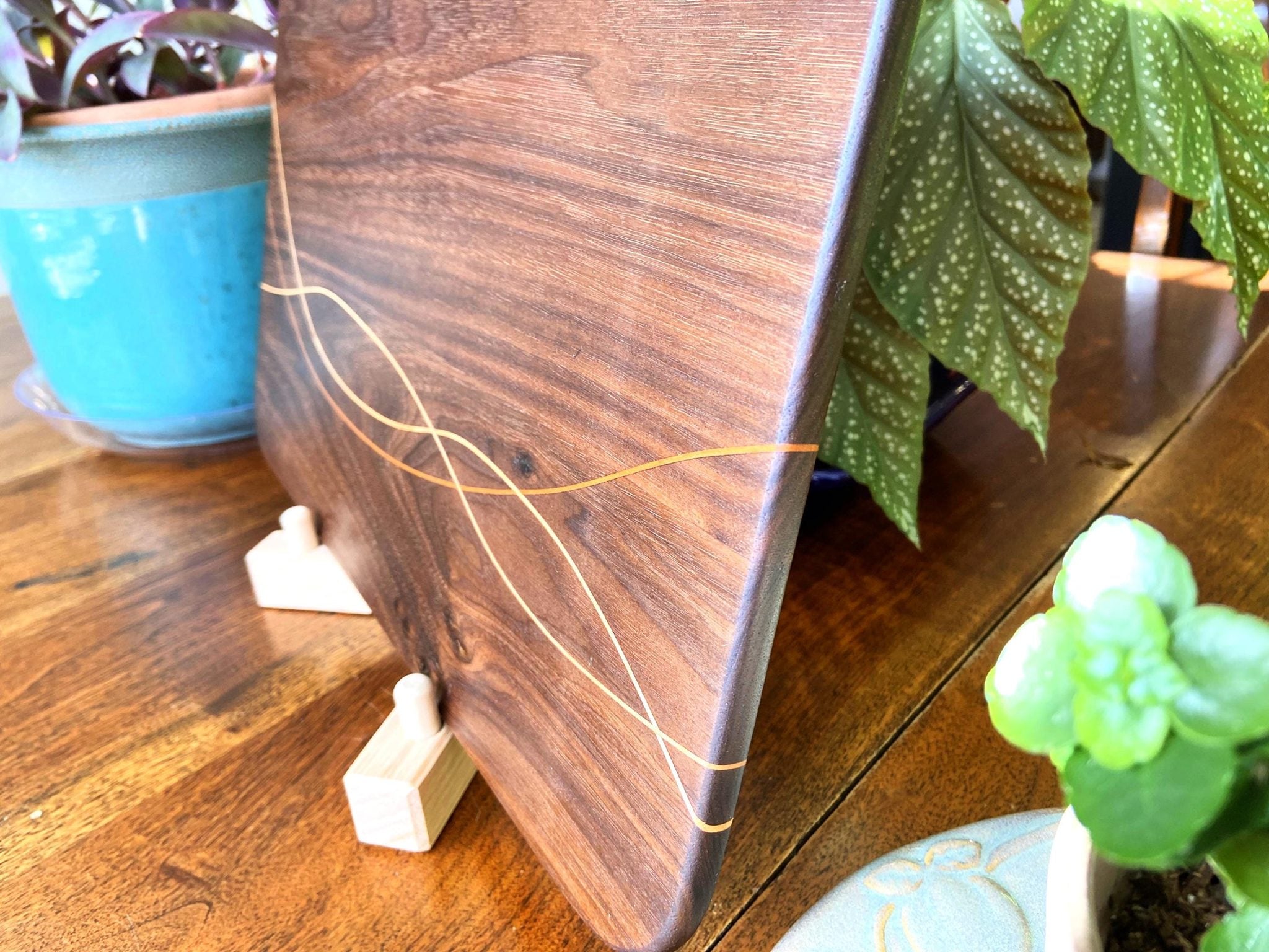 Peruvian Walnut charcuterie board with Maple and Cherry wood inlay on a table
