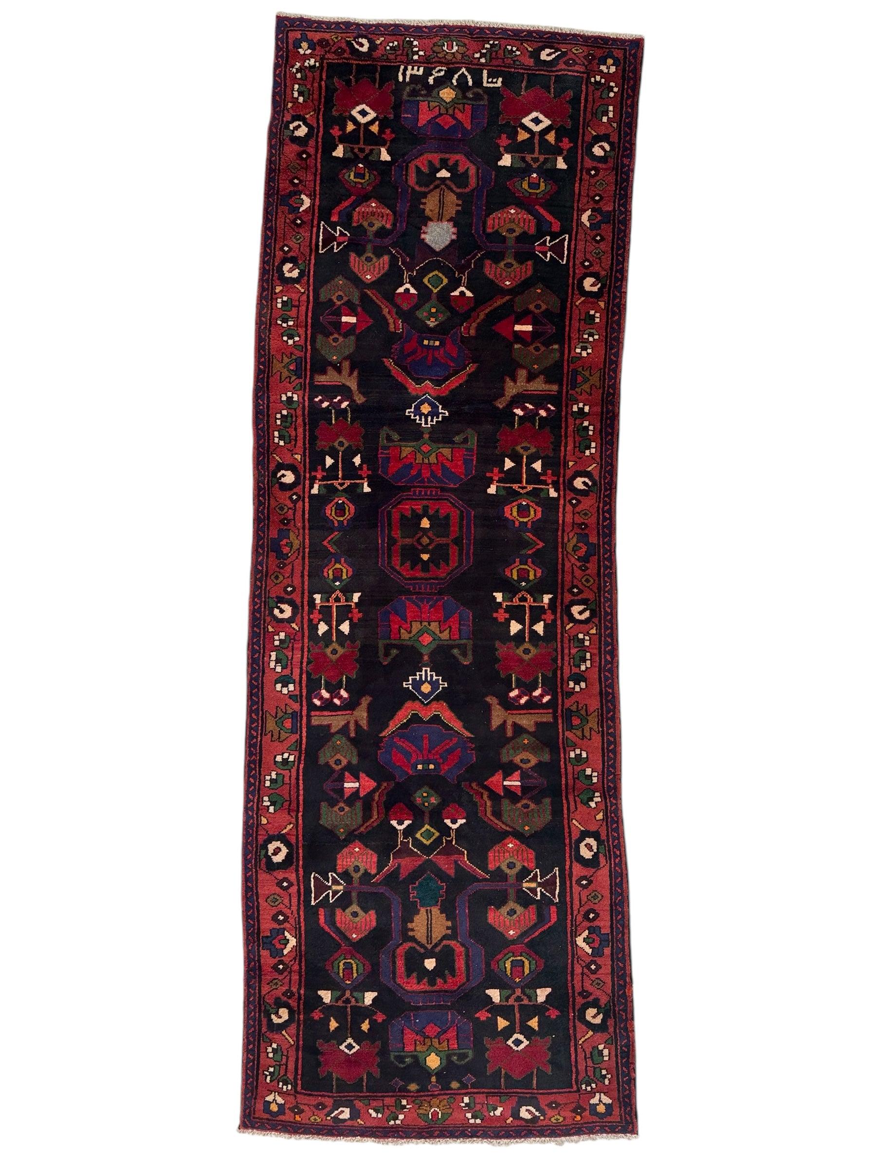 Hand-knotted Persian Hamadan tribal wool runner rug laid out on hardwood floor showing bold geometric and tribal motifs in earthy colors.