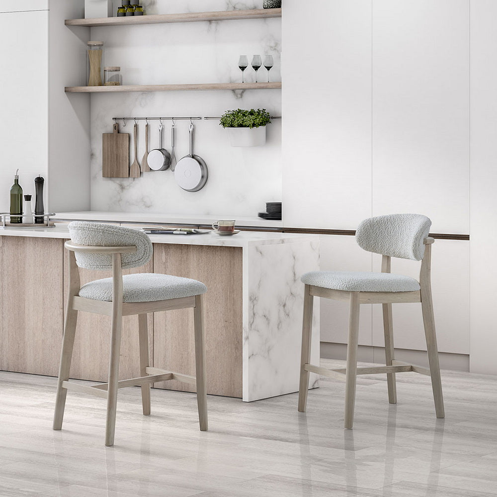 Pair of white-washed ACTU mid-century modern 26-inch upholstered counter stools beside a kitchen island
