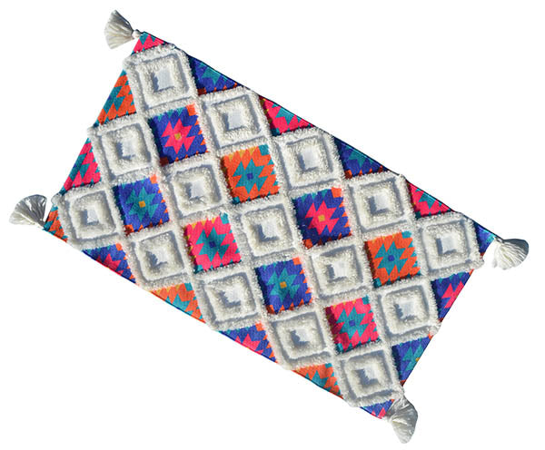 Chicos Home Accent Rug with white base and multi-color pattern, featuring fringed corners laid on light flooring
