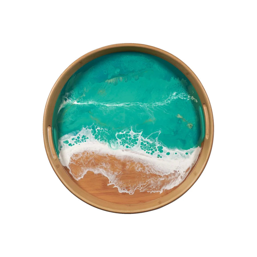 Round resin serving tray with a design resembling ocean waves on a white background
