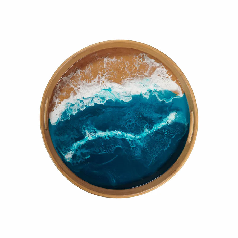 Round wooden resin serving tray with a blue ocean design and white waves on a white background