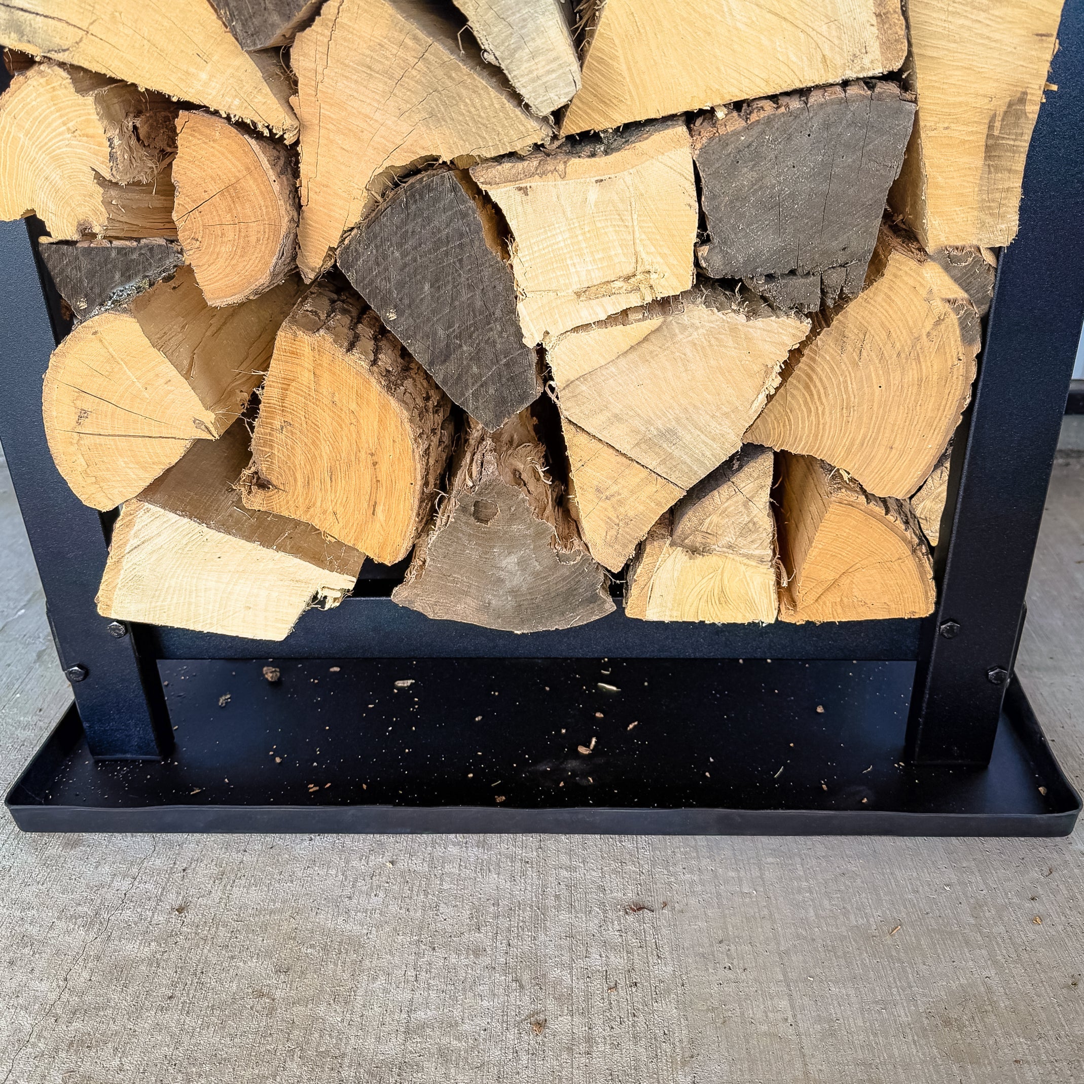 Woodhaven Multi-Purpose Firewood Rack Mat showing raised edges and waterproof surface