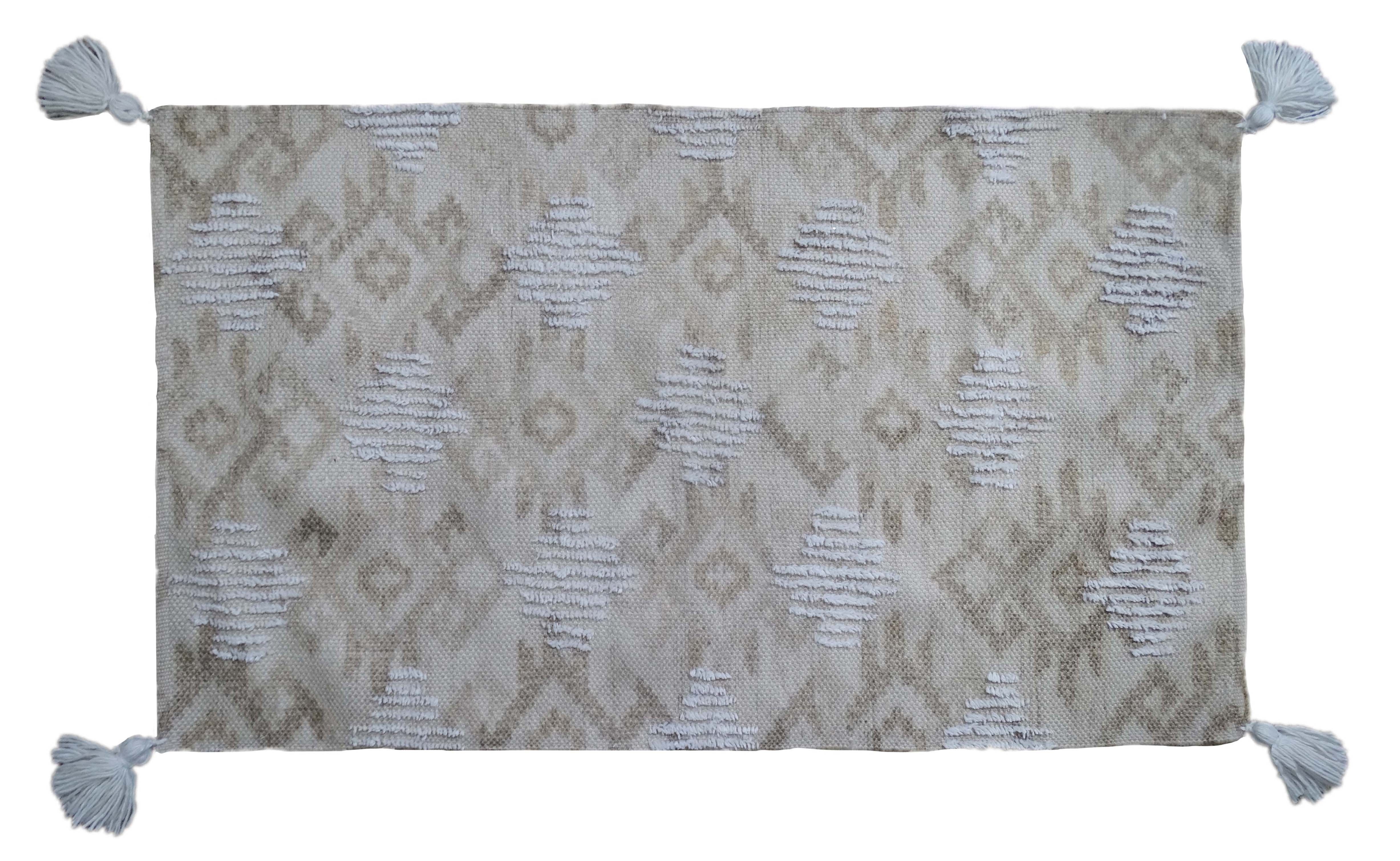 Tufted accent rug in beige tones with corner fringes laid on a tile floor
