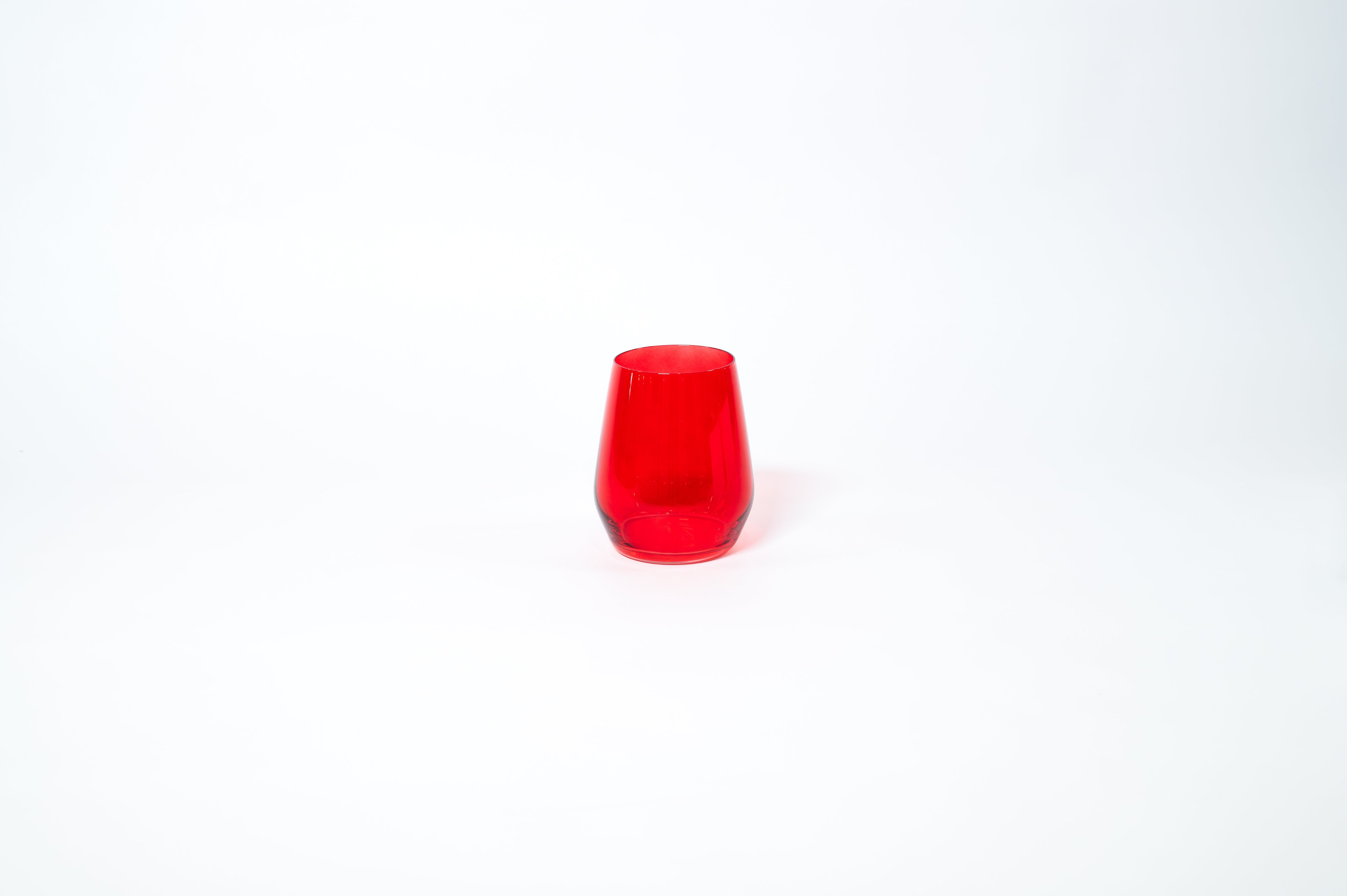 Cherry Red stemless colored wine glass showing rich red color on a clean white background
