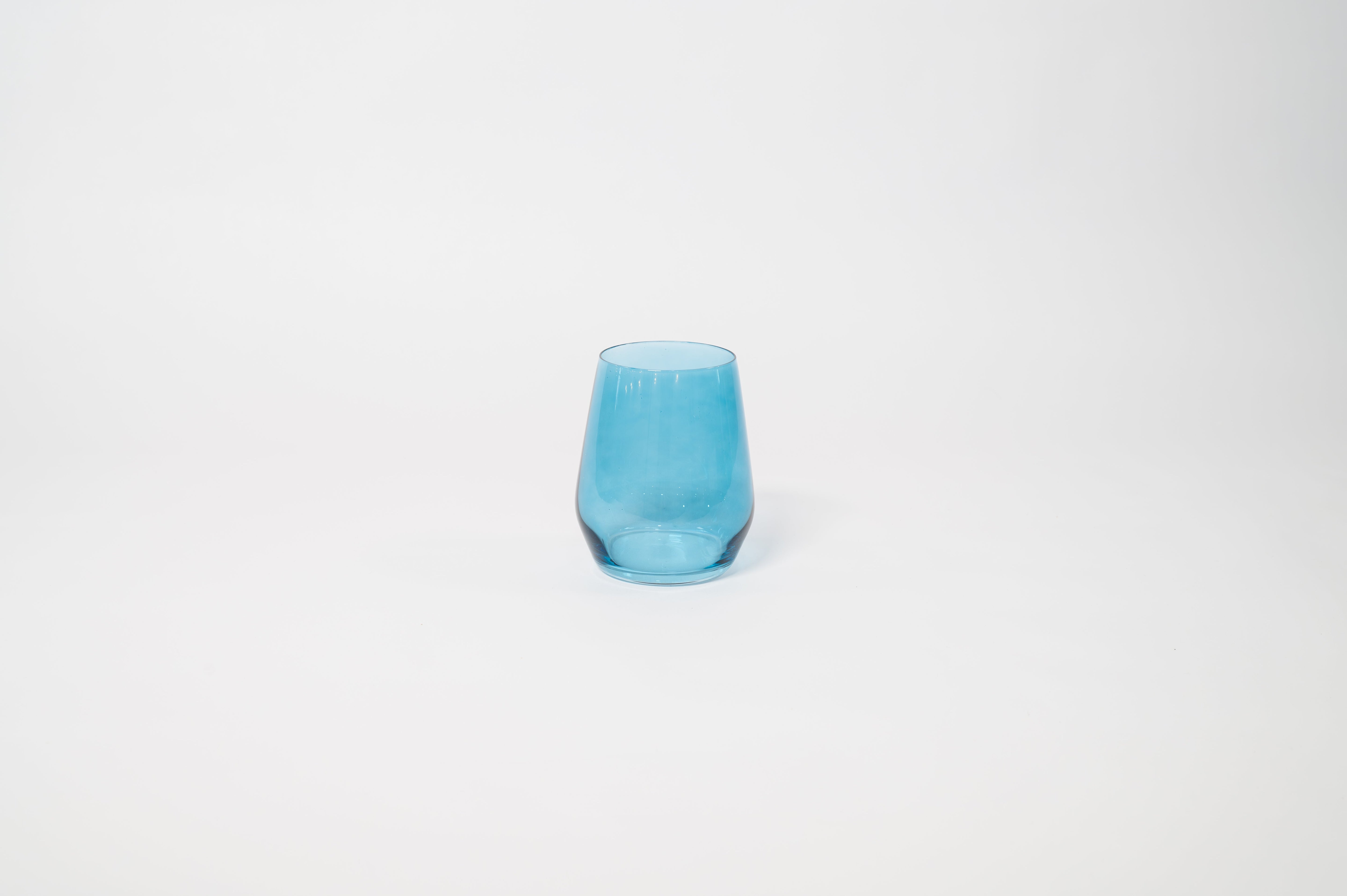 Blue Lagoon stemless colored wine glass showing soft blue tint with textured vertical ridges