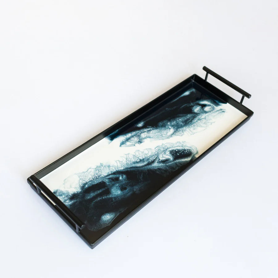 Decorative resin tray with black metal frame and abstract design on a white background