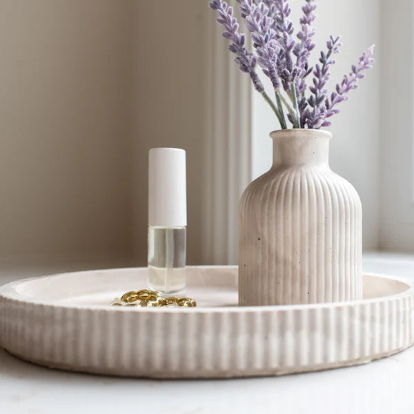 Decorative vase with lavender on a tray by a window