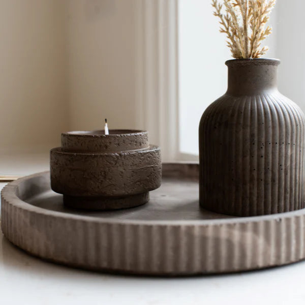 Ceramic resin vase and candle holder on a tray with a neutral background