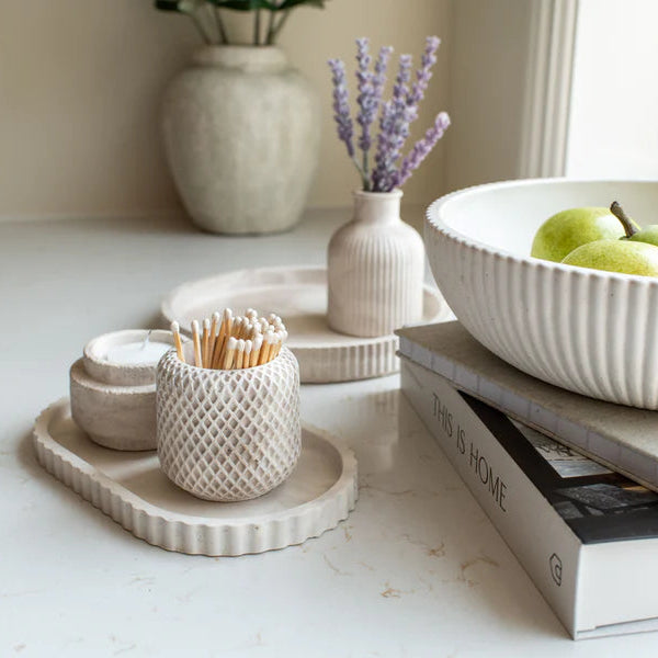 Decorative items including a bowl with apples, a vase with lavender, and a container of toothpicks on a white surface.