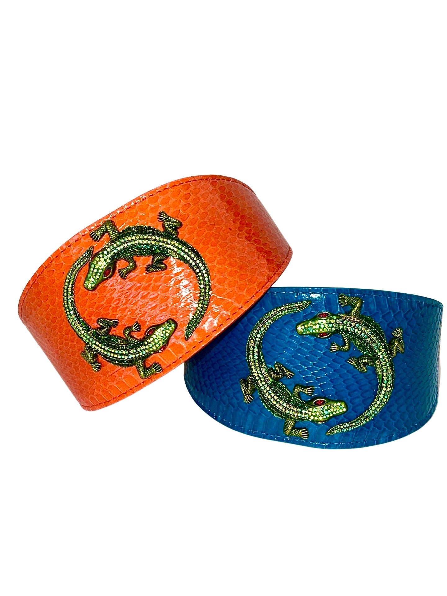 Two snake collars laid flat featuring green rhinestone alligator decorations; one orange and one dark turquoise.