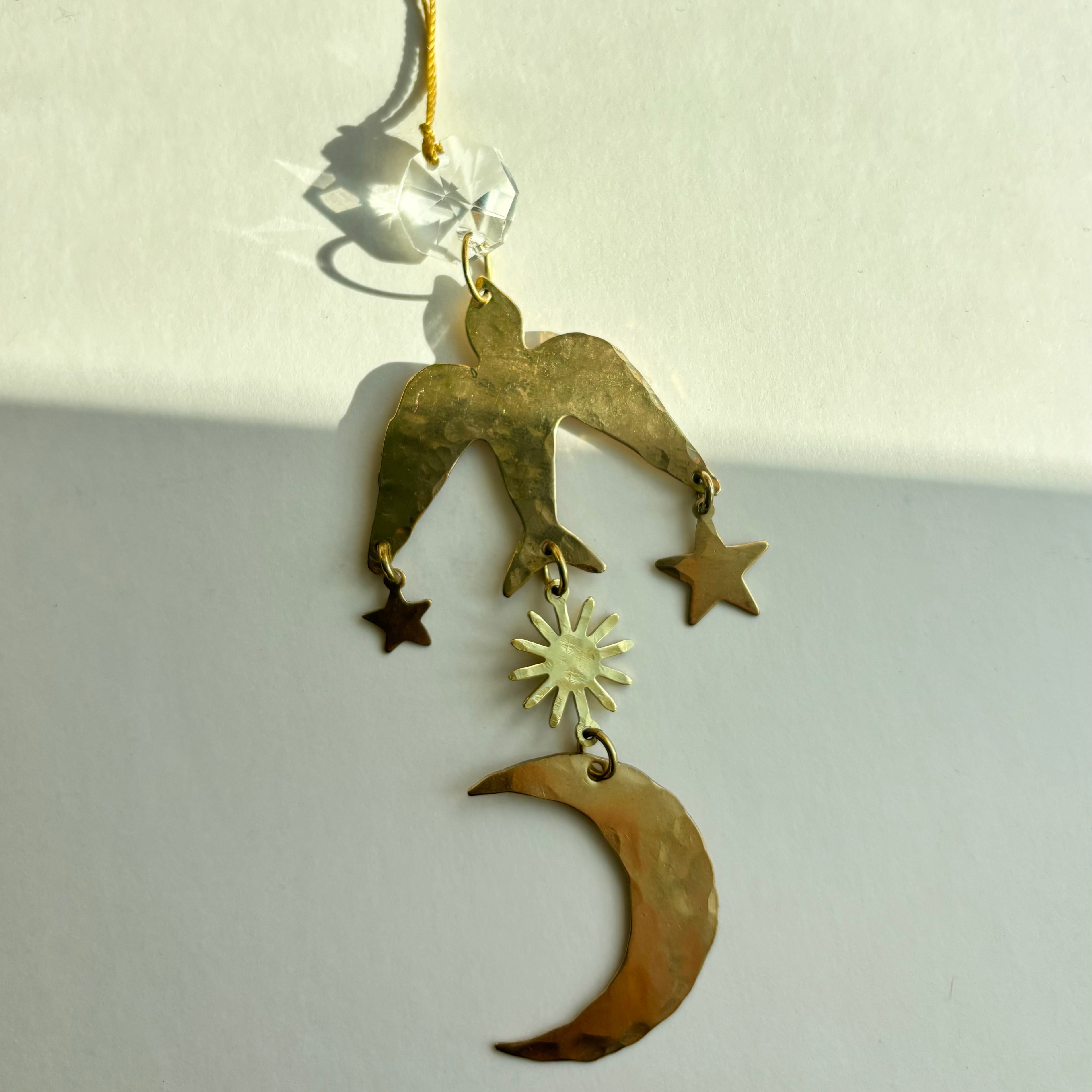 Flying Wonder Ornament by Vida + Luz, showing hand-hammered brass and vintage glass crystal hanging decor