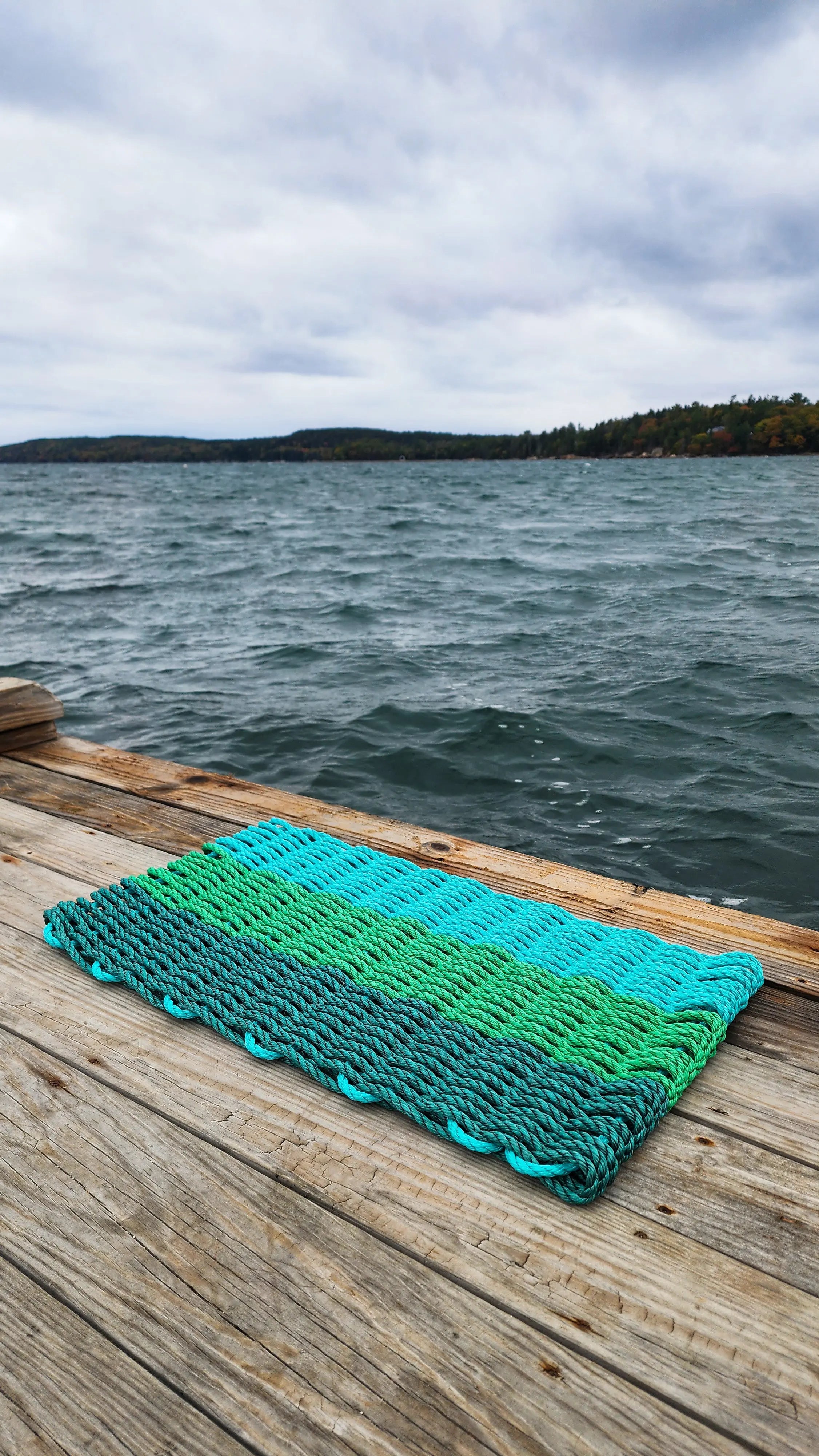 Green ombre handmade rope mat made with lobster rope in hunter green, green, and teal colors