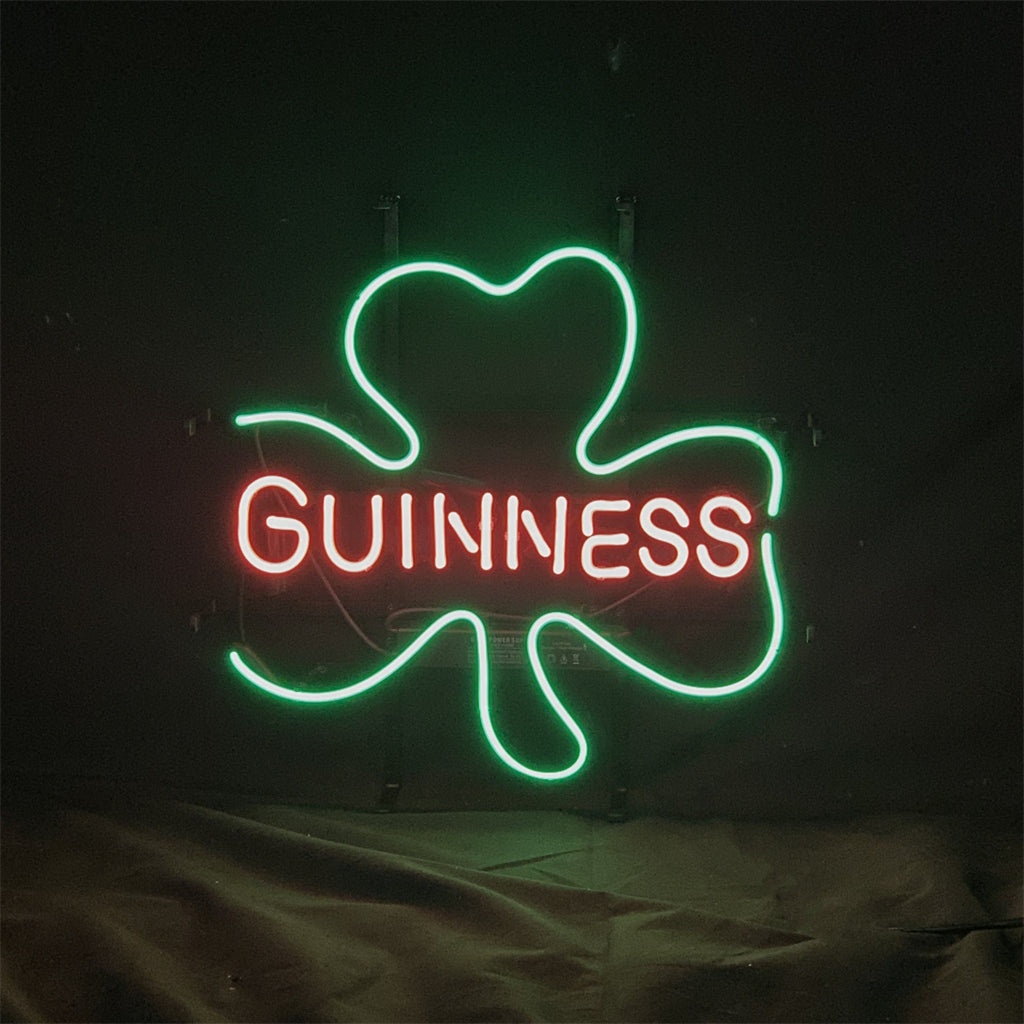 Guinness with Clover Lager Beer Neon Sign Light glowing against a dark background