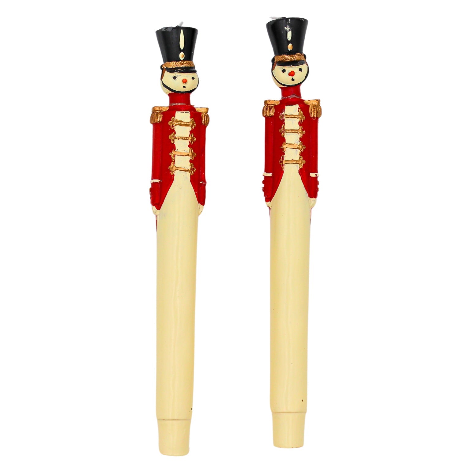 Two handpainted red royal guard candles with navy blue coat, gold trim, and black detail displayed upright on a white surface.
