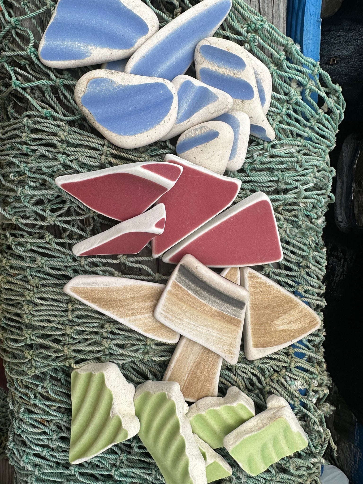 Assorted hand-tumbled pottery pieces in earthy colors for mosaic crafts