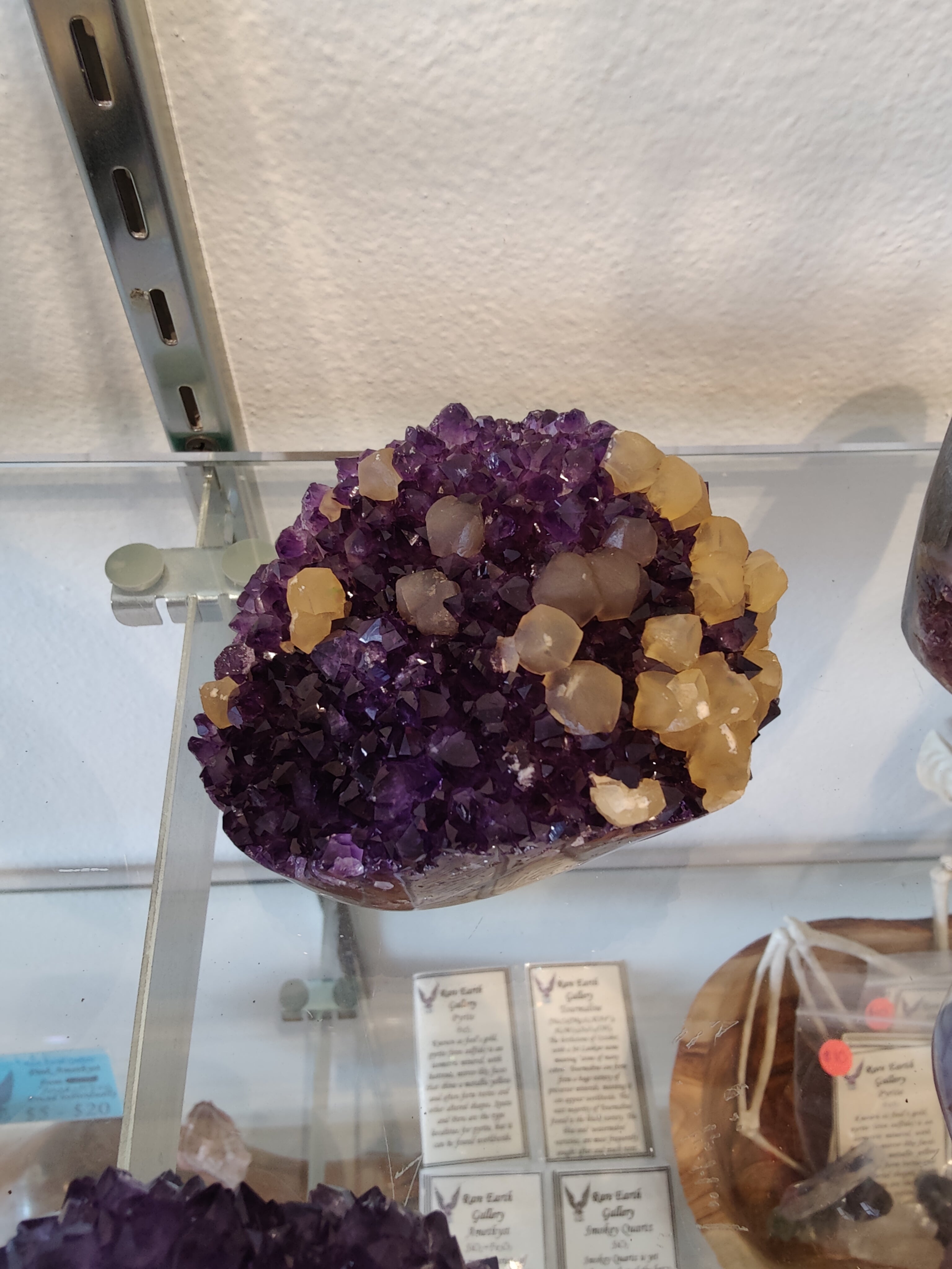 Polished amethyst geode sculpture with golden calcite crystal inclusions
