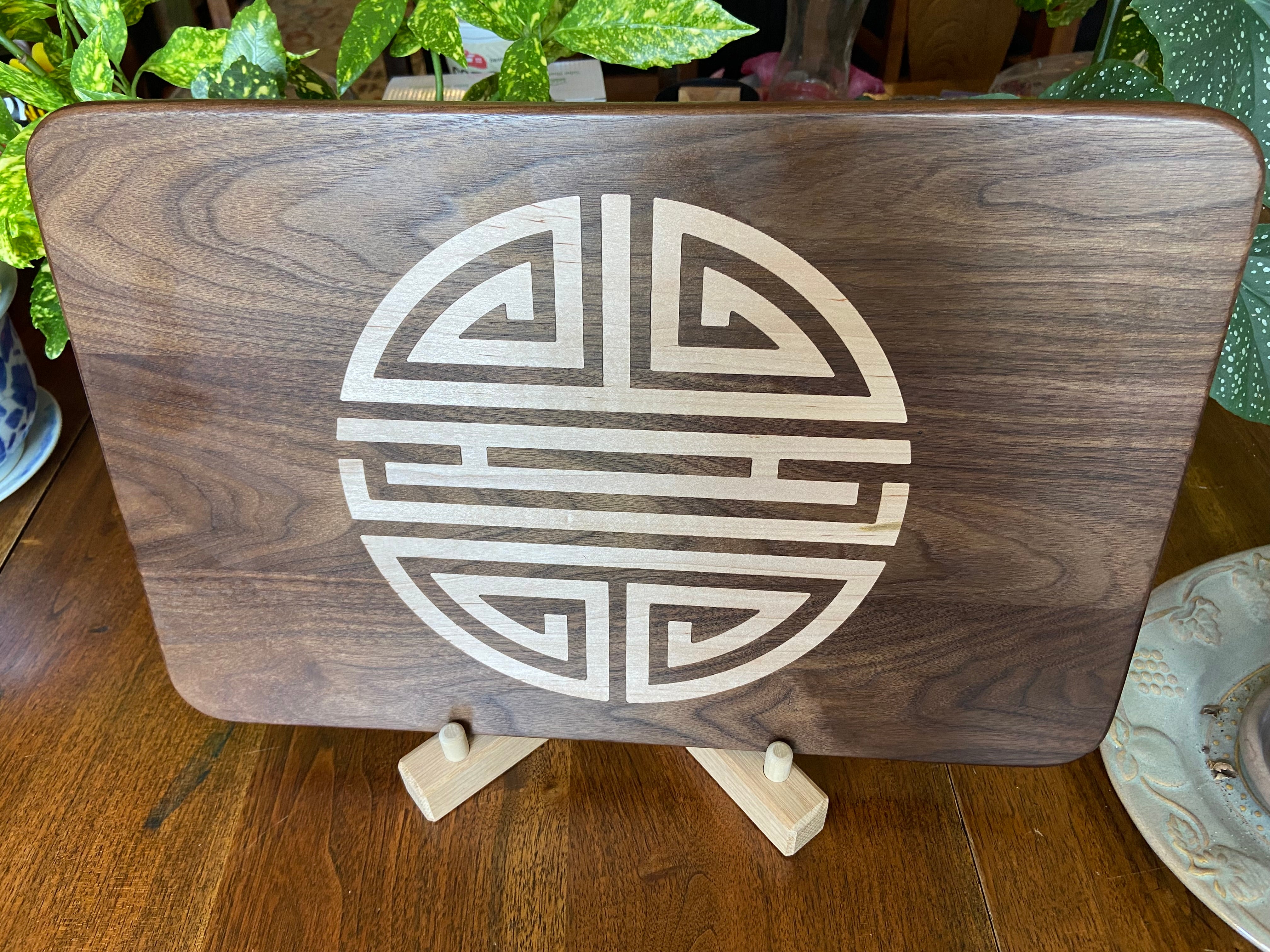 Walnut charcuterie board with Chinese Shou symbol inlay by Fitzgerald Custom Woodcraft