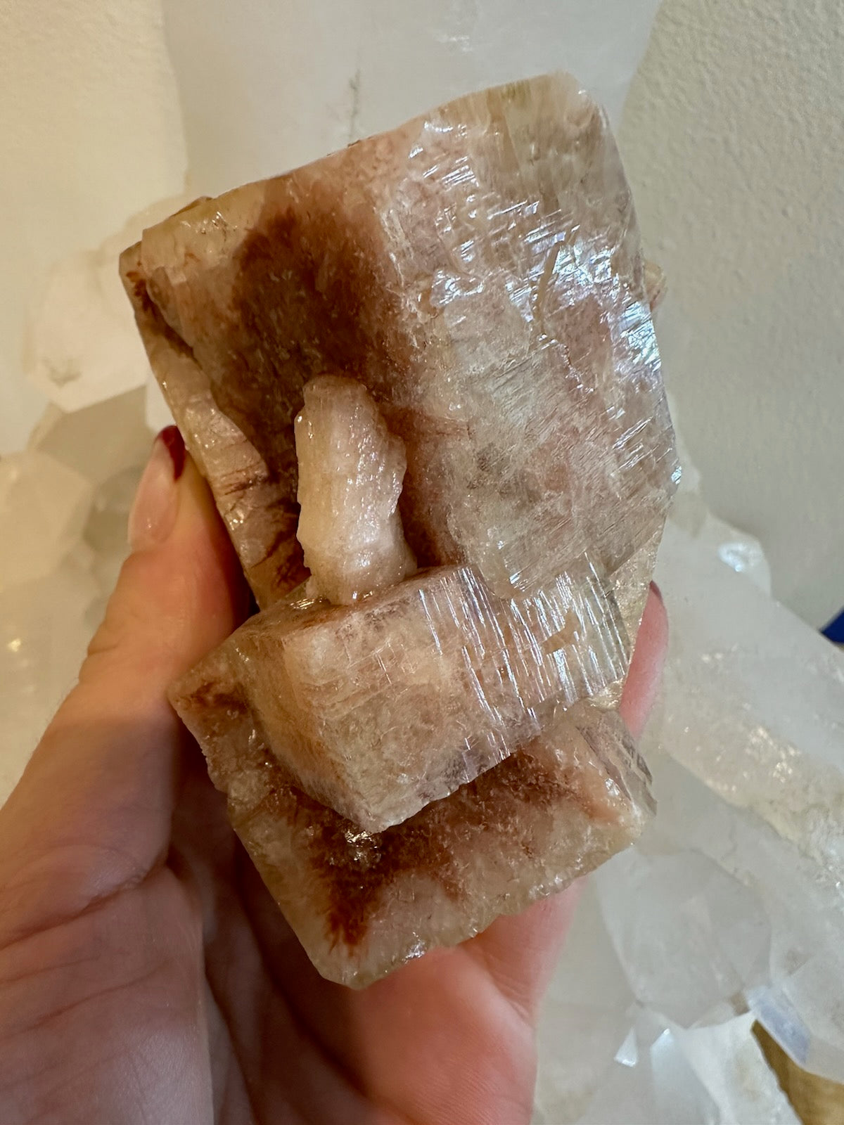 Red apophyllite cube cluster mineral specimen displayed on a white surface
