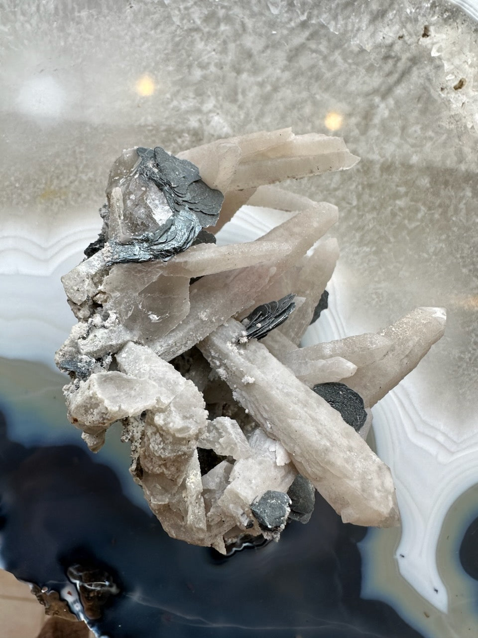 Dogtooth Calcite Cluster with Mica flakes displayed against a neutral background