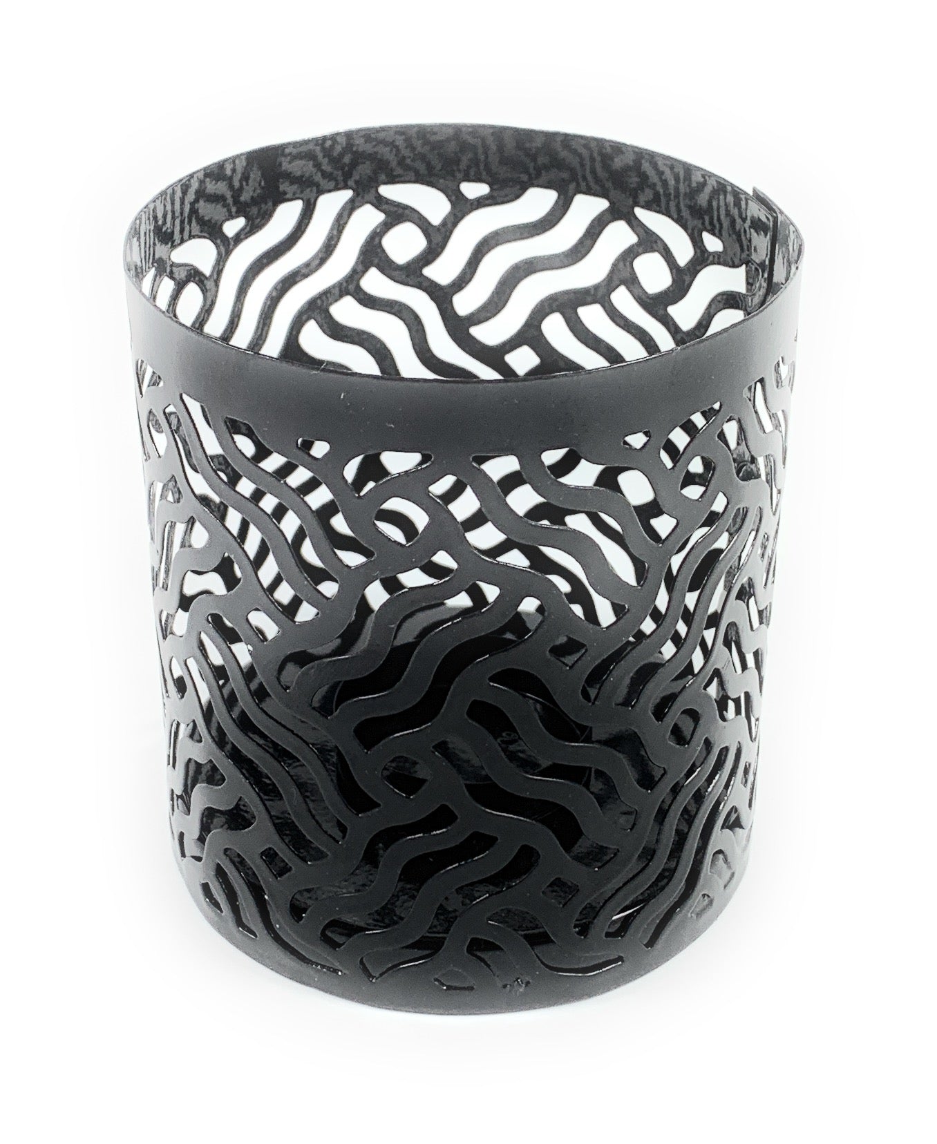 Two grey votive candle holders with laser cut patterns casting shadows