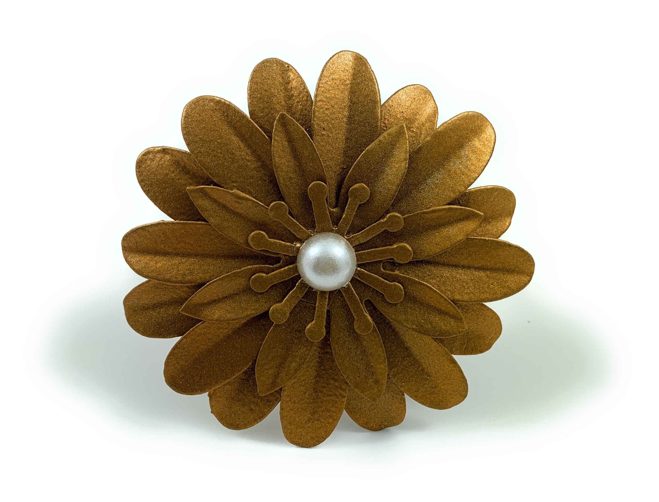Set of four golden floral napkin rings with pearl accents arranged on a white surface