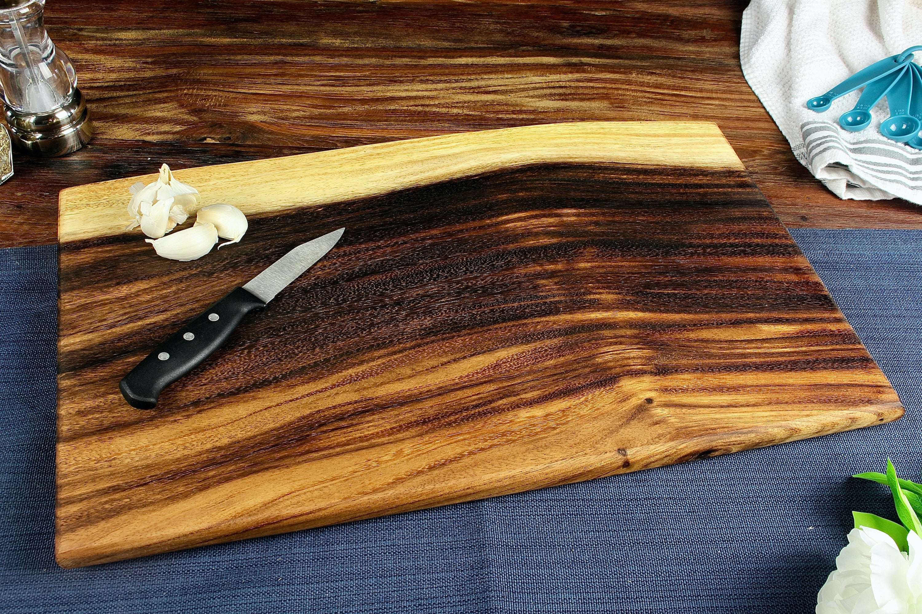 Large live edge square end cutting board made from East Indian Walnut, shown in natural wood finish