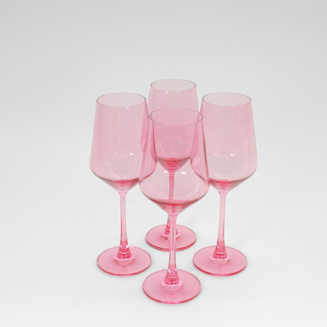 Bubblegum Pink colored wine glass from GlassHauseCo set against a neutral background