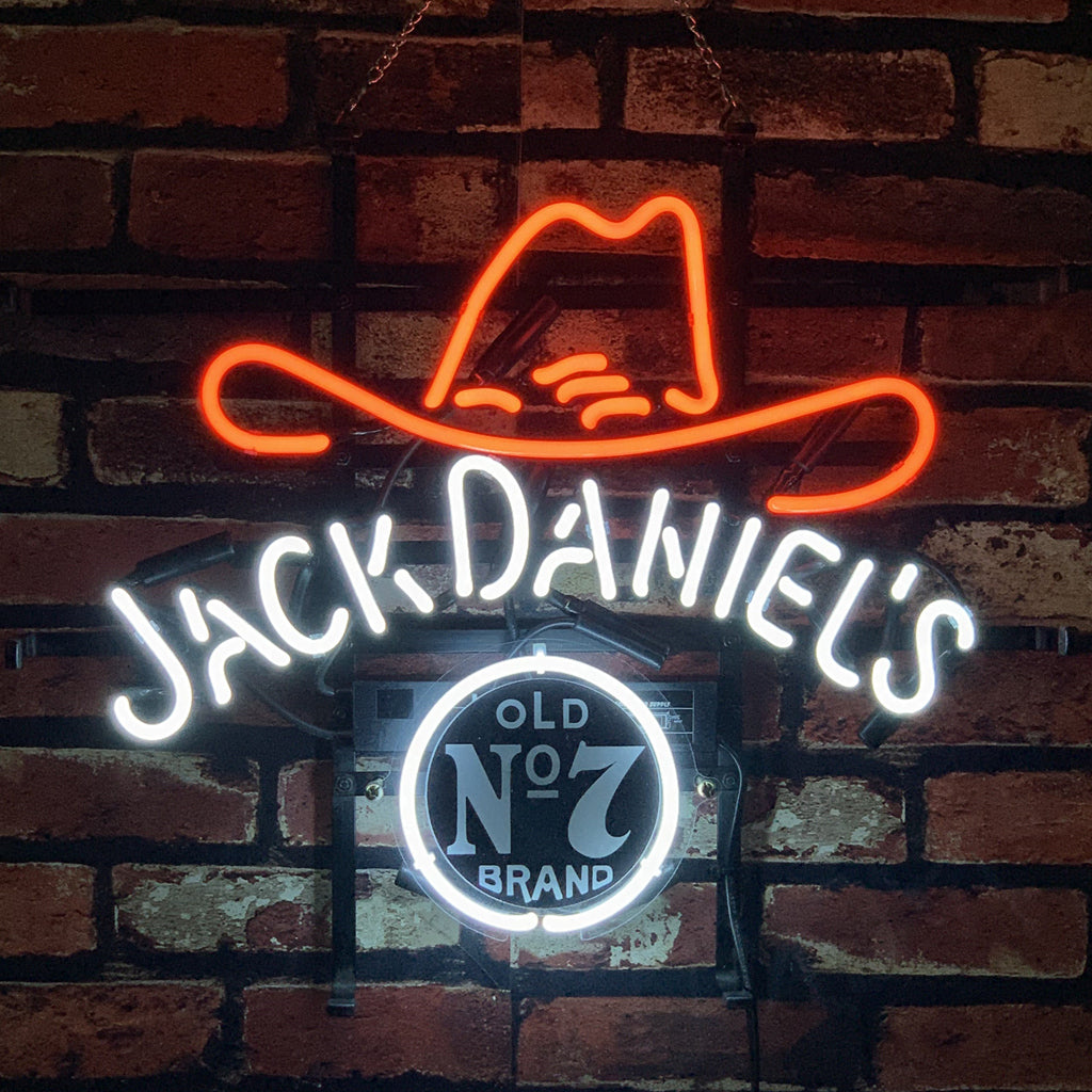 Jack Daniel's Old No.7 Whiskey Neon Sign illuminated in a room with cowboy hat and rustic decor
