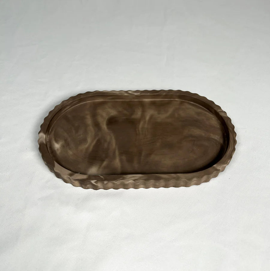 Brown ceramic tray with decorative edge on a white background