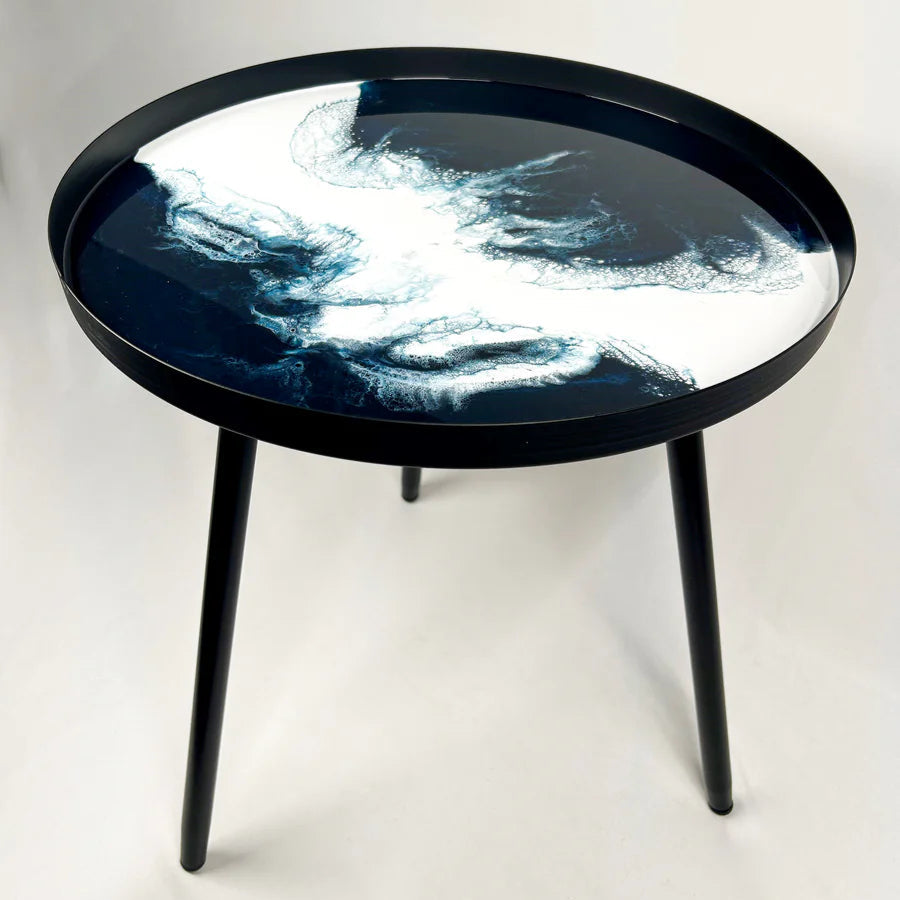 Round resin black table with a reflective surface on a white background
